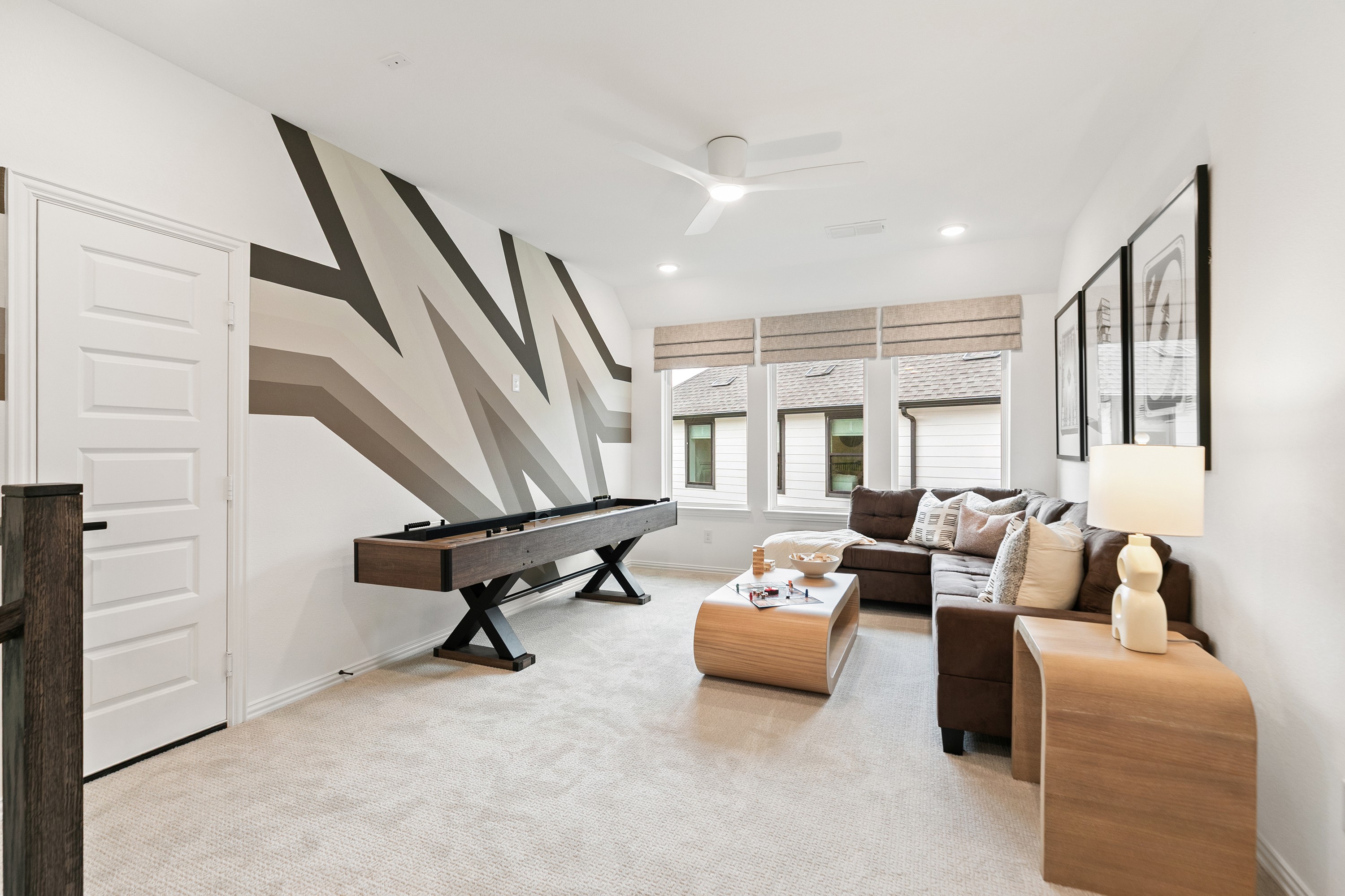 Katy Lakes Game Room with Modern Zigzag Wall and Shuffleboard Modern Katy Lakes game room with zigzag wall, shuffleboard, cozy sectional, stylish decor.