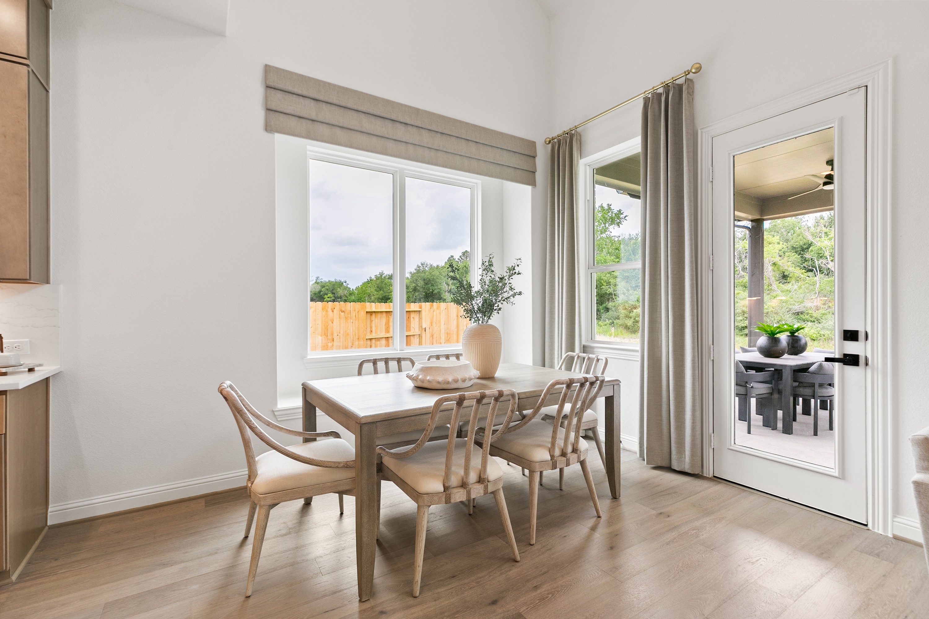 Luxurious Dining Room in Katy Lakes Home with Scenic Views Elegant dining room with wooden table, large windows, and glass door in Katy Lakes home.