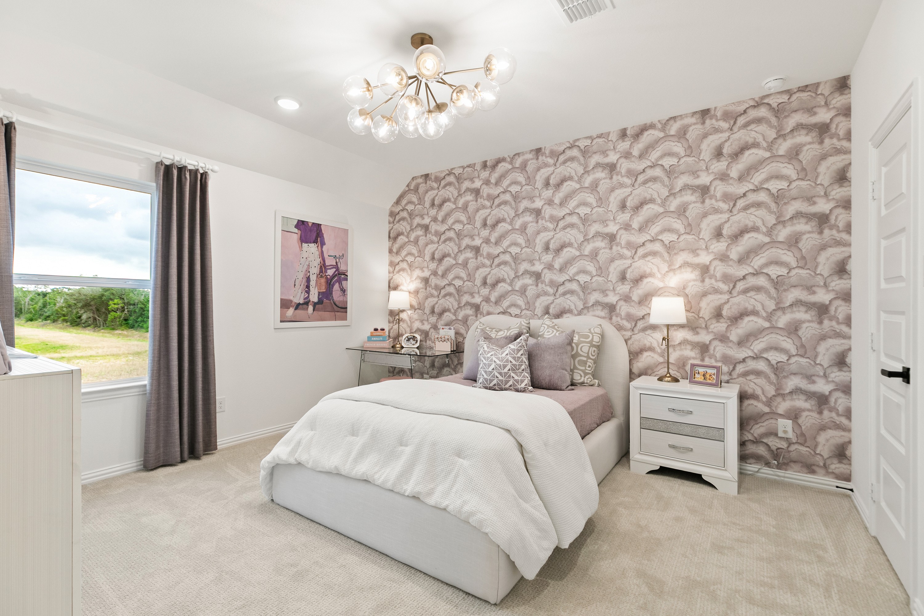 Stylish Bedroom with Cloud-Patterned Feature Wall in Katy Lakes Elegant bedroom with cloud-patterned accent wall, chic chandelier, beige carpet in Katy Lakes, TX.