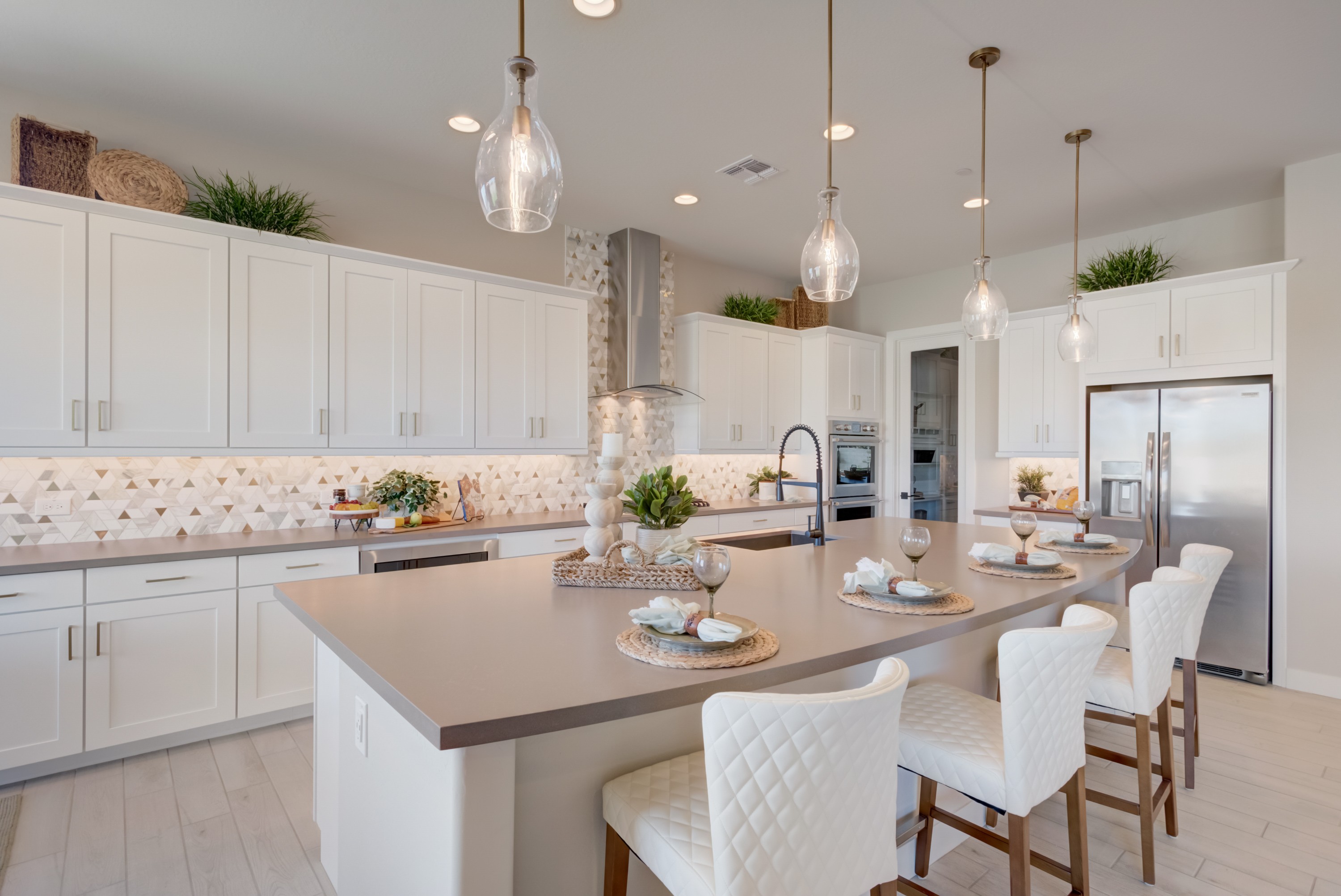 Modern Luxury Kitchen with Quartz Countertops in Arroyo Seco Elegant kitchen with quartz counters, pendant lights, geometric backsplash in Arroyo Seco's Palazzo community.