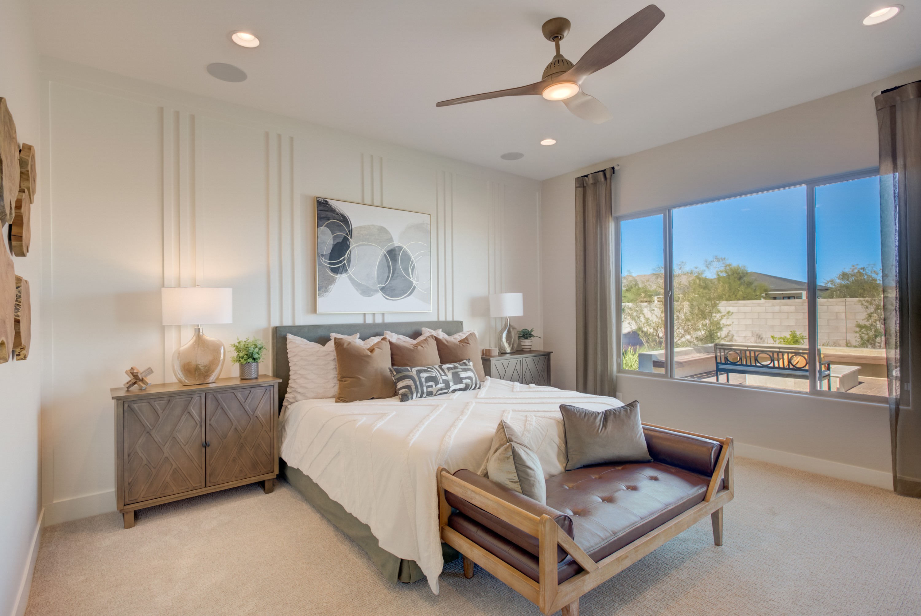 Luxury Bedroom Design in Palazzo, Arroyo Seco Community Elegant bedroom with plush bedding, large window, designer fan in Arroyo Seco, Palazzo. Modern wood furniture, abstract decor.