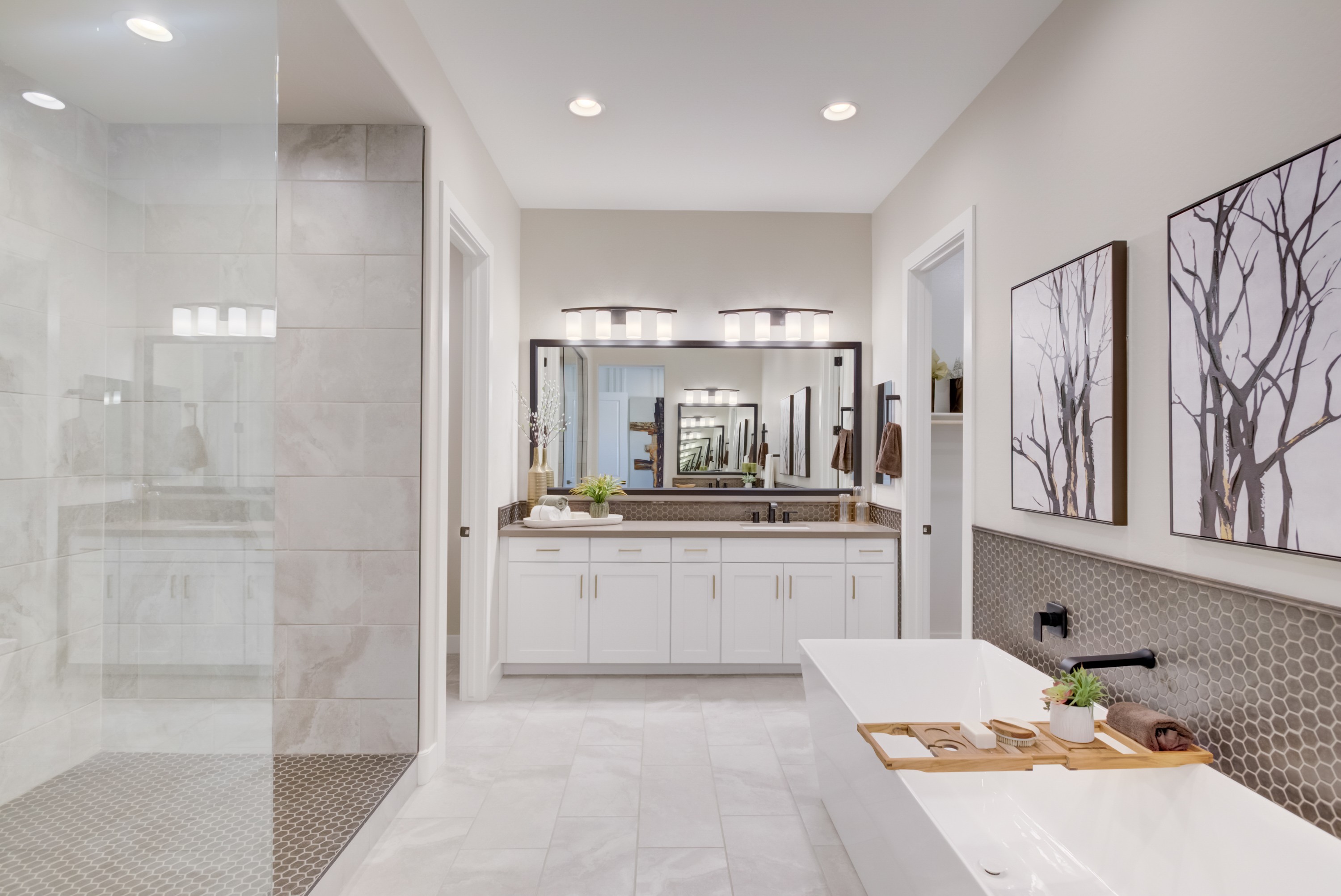 Elegant Bathroom with Soaking Tub in Arroyo Seco Palazzo Community Luxurious bathroom features white cabinetry, large mirror, soaking tub, hexagonal tiles in Arroyo Seco's Palazzo community.
