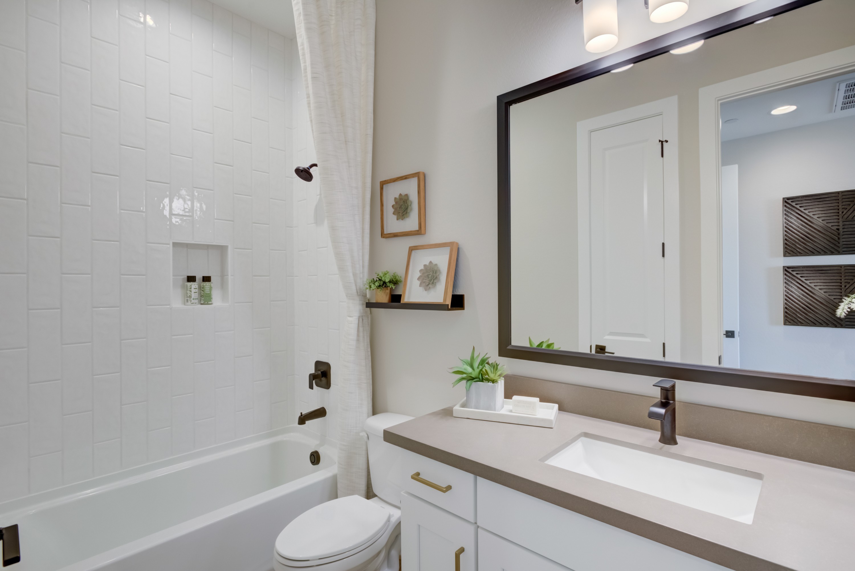 Luxurious Bathroom Design in Arroyo Seco's Palazzo Community Elegant white bathroom with subway tiles, modern faucet, large mirror. Arroyo Seco, Palazzo community.