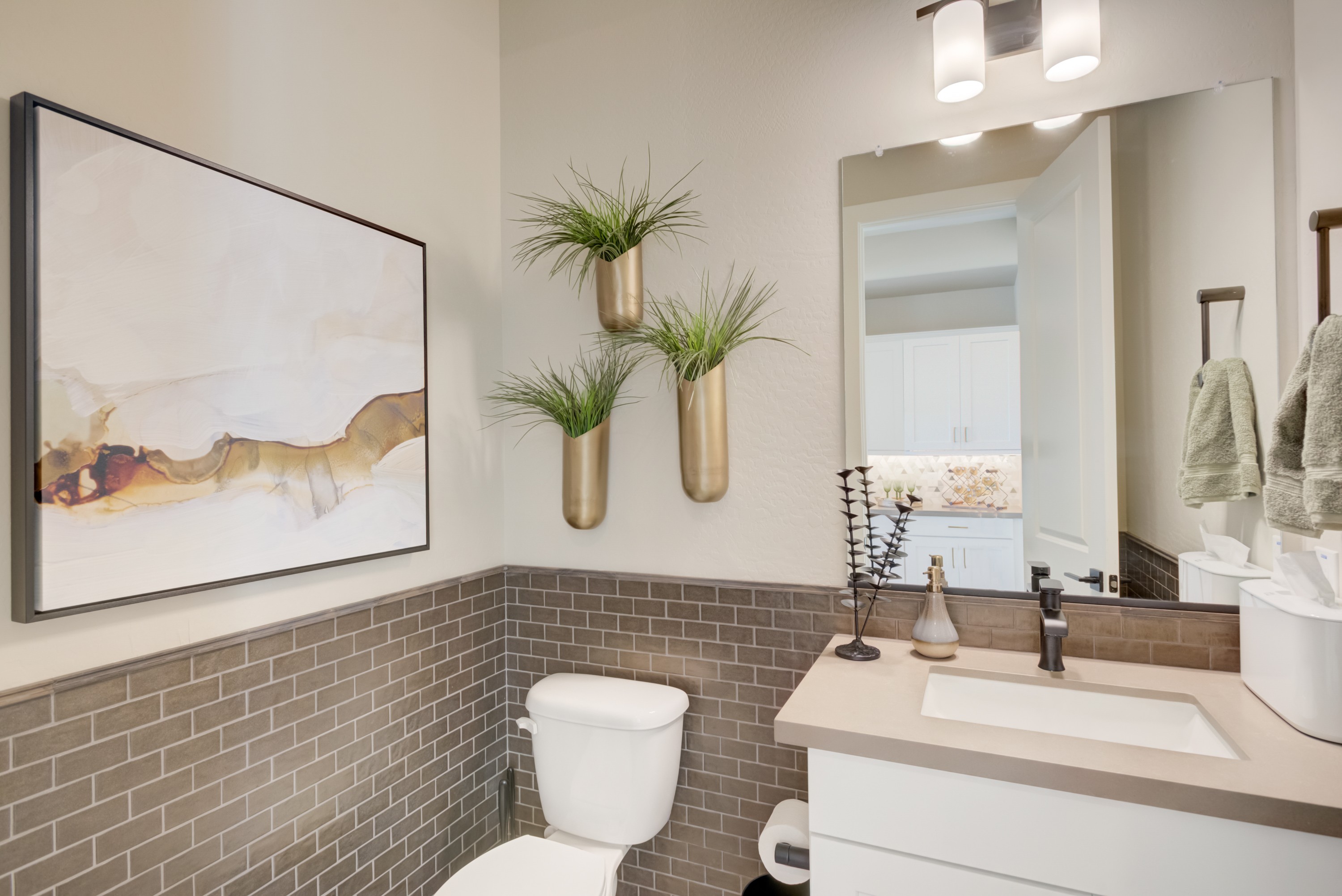 Luxurious Bathroom in Arroyo Seco - Palazzo Community Elegant bathroom features beige walls, brown tile wainscoting, abstract art, chic lighting in Arroyo Seco - Palazzo.