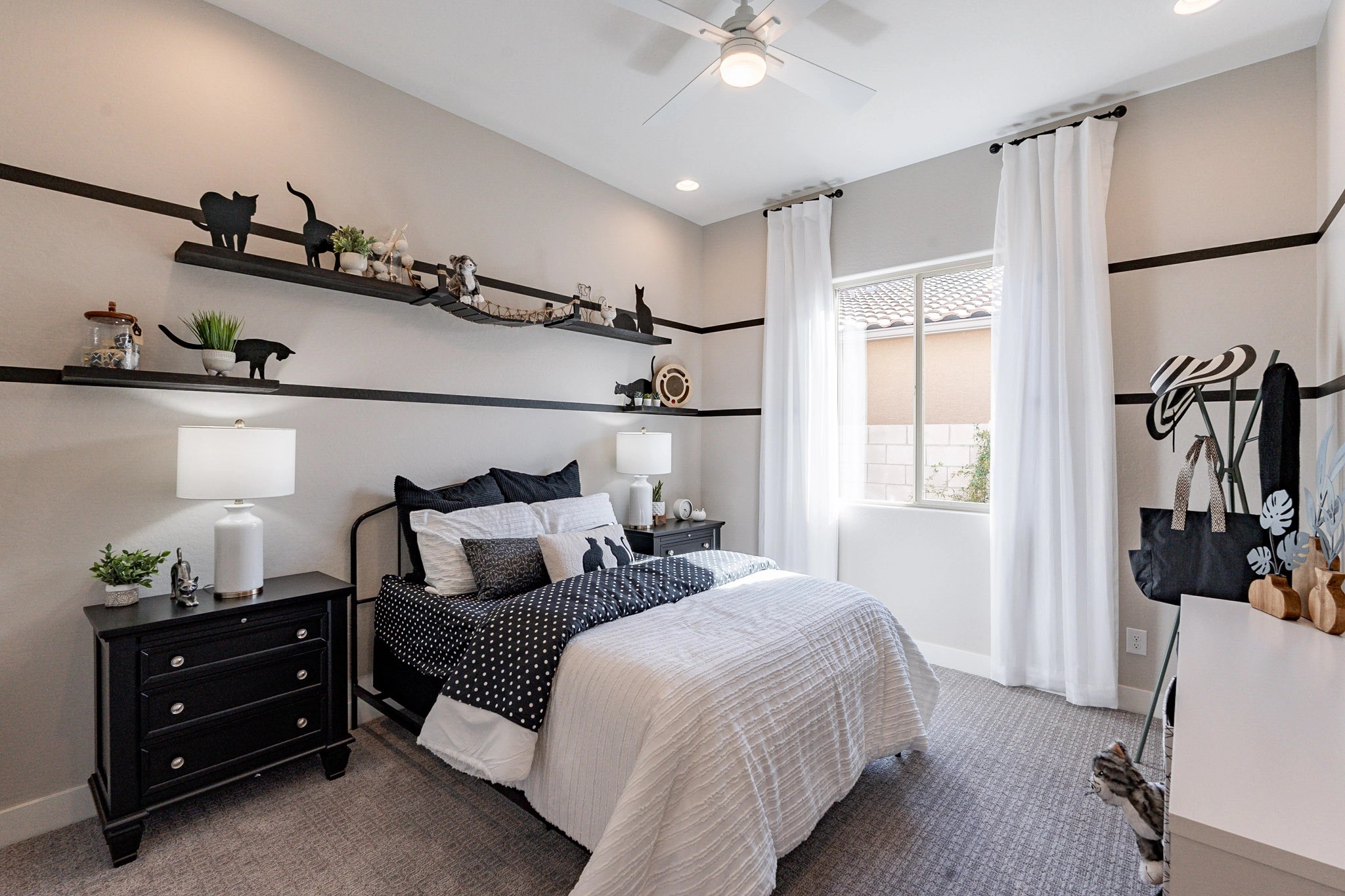 Elegant Bedroom in Arroyo Seco Hacienda Community Modern bedroom with black decor accents, neutral tones, and ample natural light. Arroyo Seco Hacienda community.