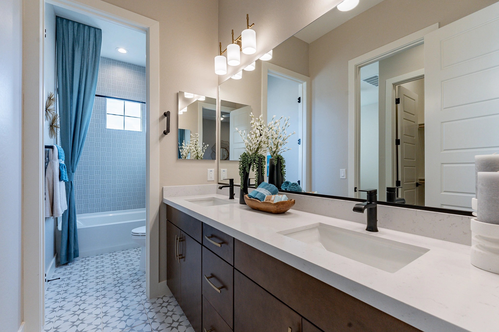 Elegant Dual-Sink Bathroom with Geometric Tiles in Arroyo Seco Modern bathroom with dual sinks, elegant fixtures, and geometric floor tiles in Arroyo Seco Hacienda community.