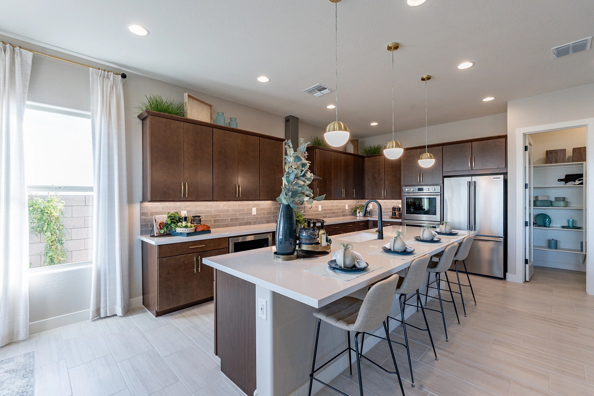 Modern Kitchen with Island in Arroyo Seco Hacienda Home Modern kitchen with dark wood cabinets, island, pendant lights. Arroyo Seco Hacienda, open shelving, sleek appliances.