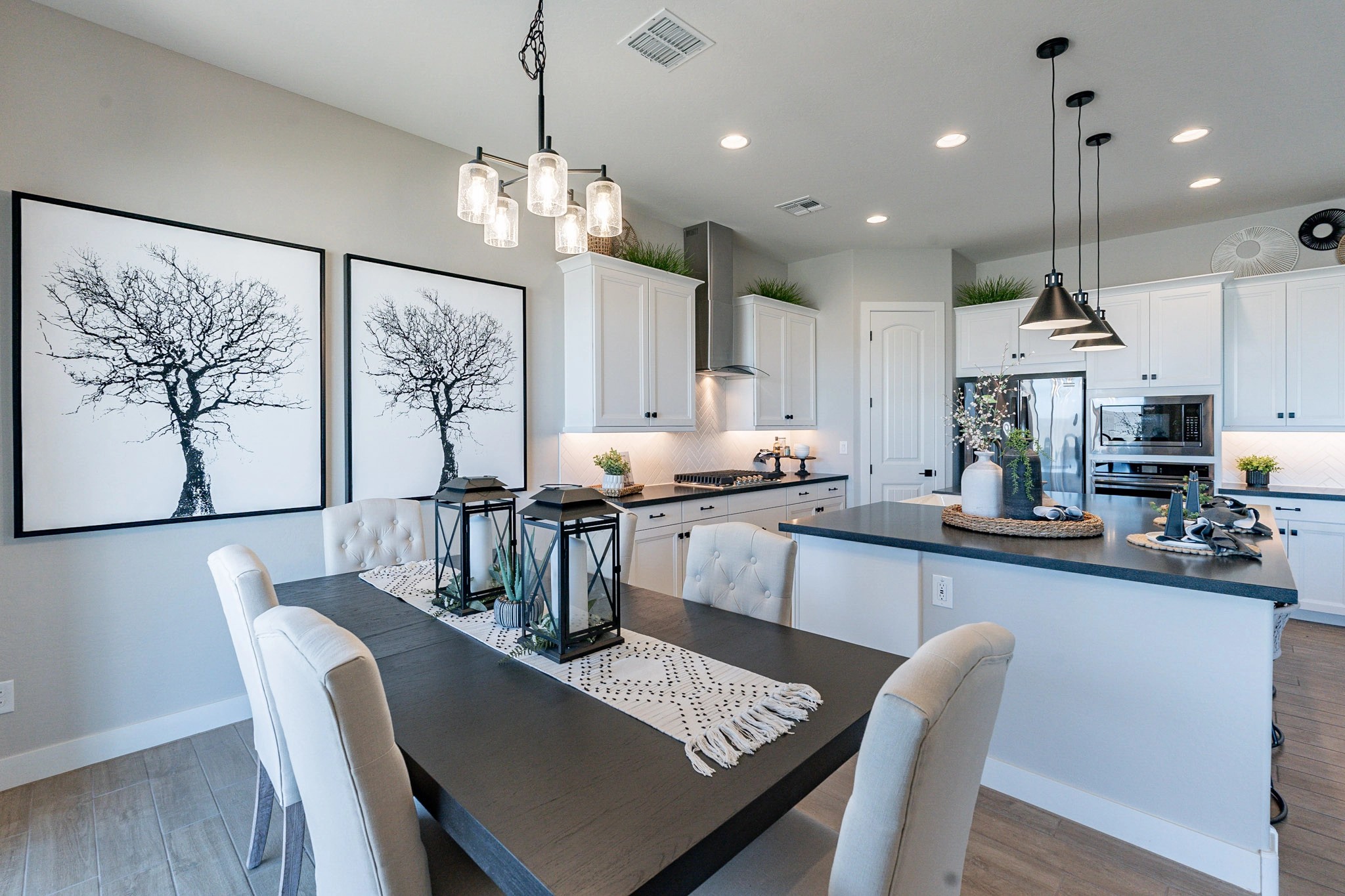 Modern Kitchen in Arroyo Seco Hacienda with Black Countertops Modern kitchen with black countertops, white cabinets, elegant pendant lighting in Arroyo Seco Hacienda community.