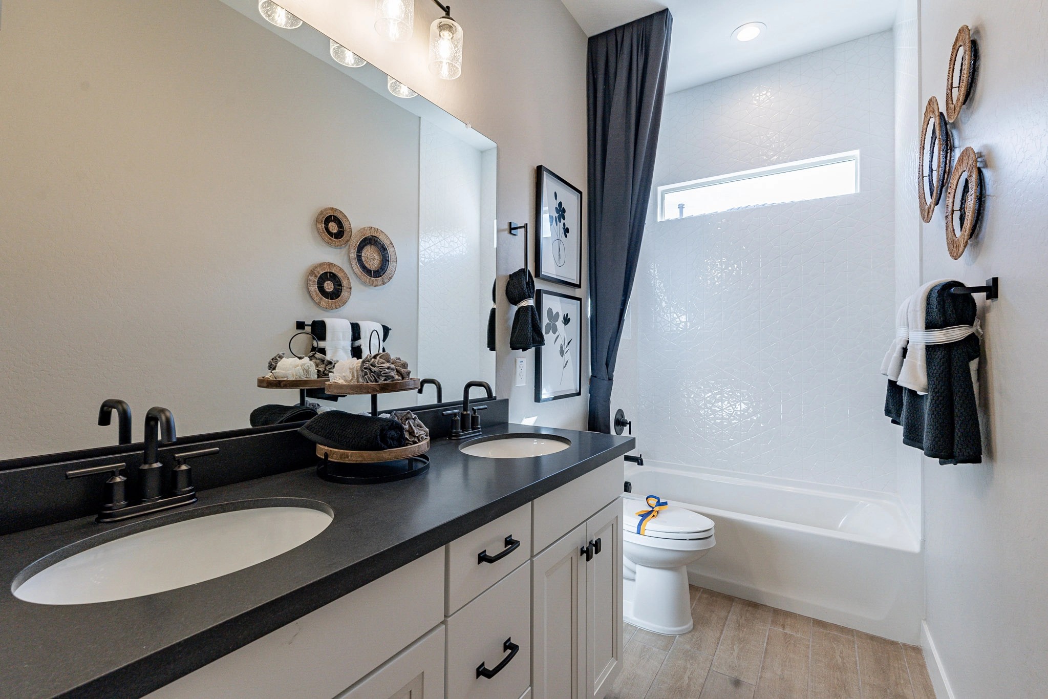 Dual Sink Bathroom with Black Fixtures in Arroyo Seco Hacienda Modern bathroom with dual sinks, black fixtures, and elegant decor in Arroyo Seco Hacienda community.