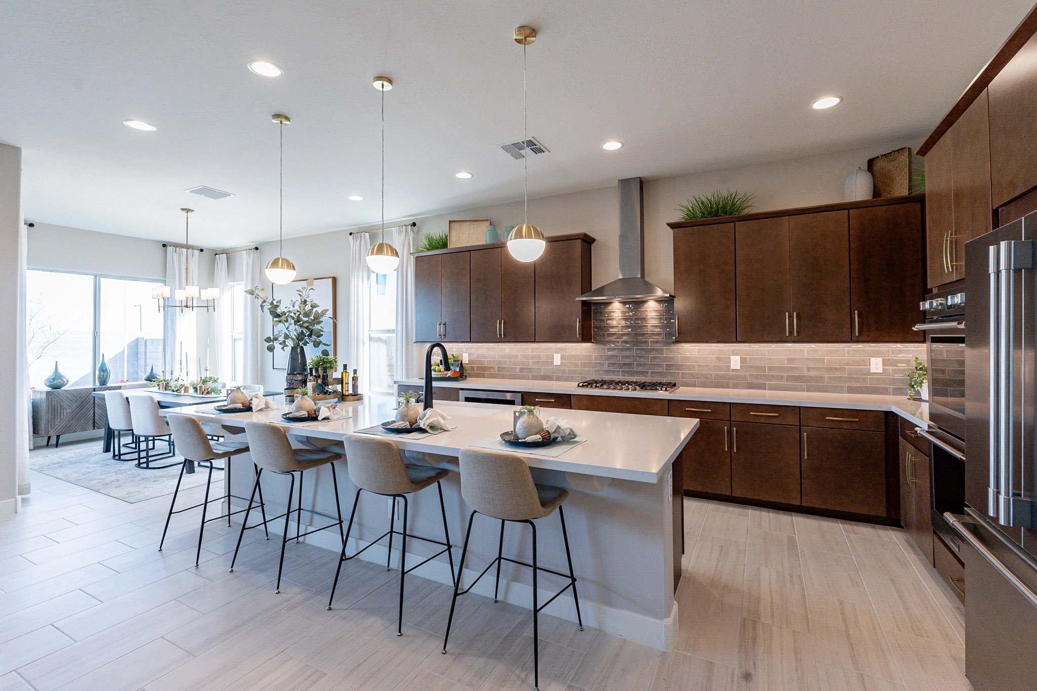 Arroyo Seco Hacienda Modern Kitchen with Island and Pendant Lights Modern kitchen with dark wood cabinets, large island, and pendant lights in Arroyo Seco Hacienda community.