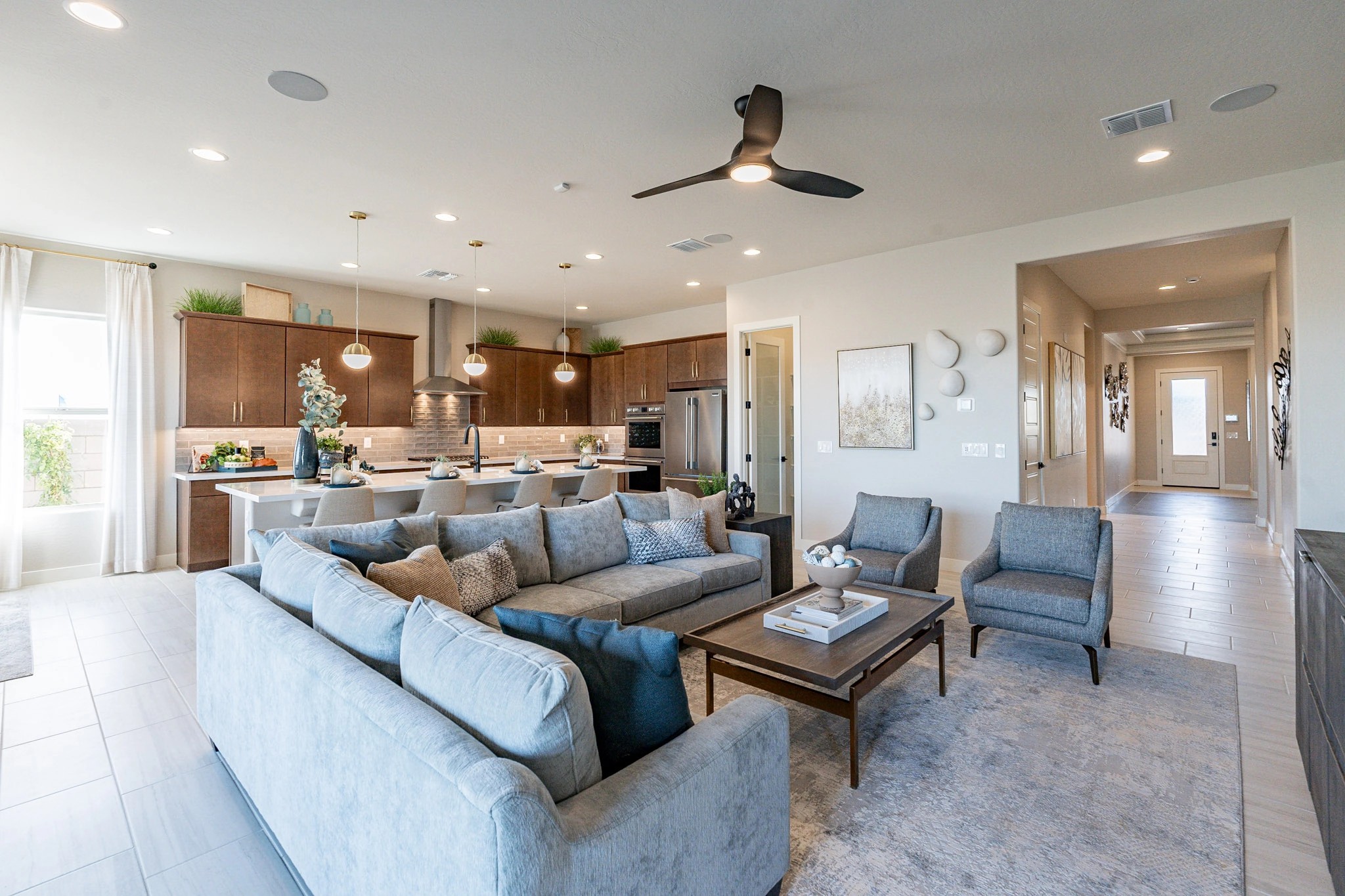 Arroyo Seco Hacienda Living Room with Open Kitchen Design Modern living room with plush sofas, open kitchen, pendant lights, and wood cabinetry in Arroyo Seco Hacienda.