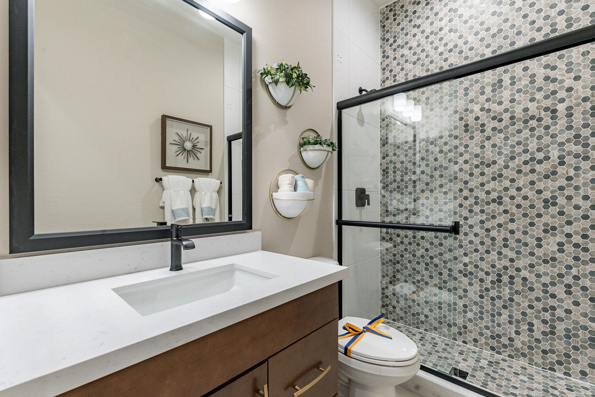 Luxury Modern Bathroom in Arroyo Seco Hacienda Community Modern bathroom with hexagonal tile shower, sleek vanity, and large mirror in Arroyo Seco Hacienda community.