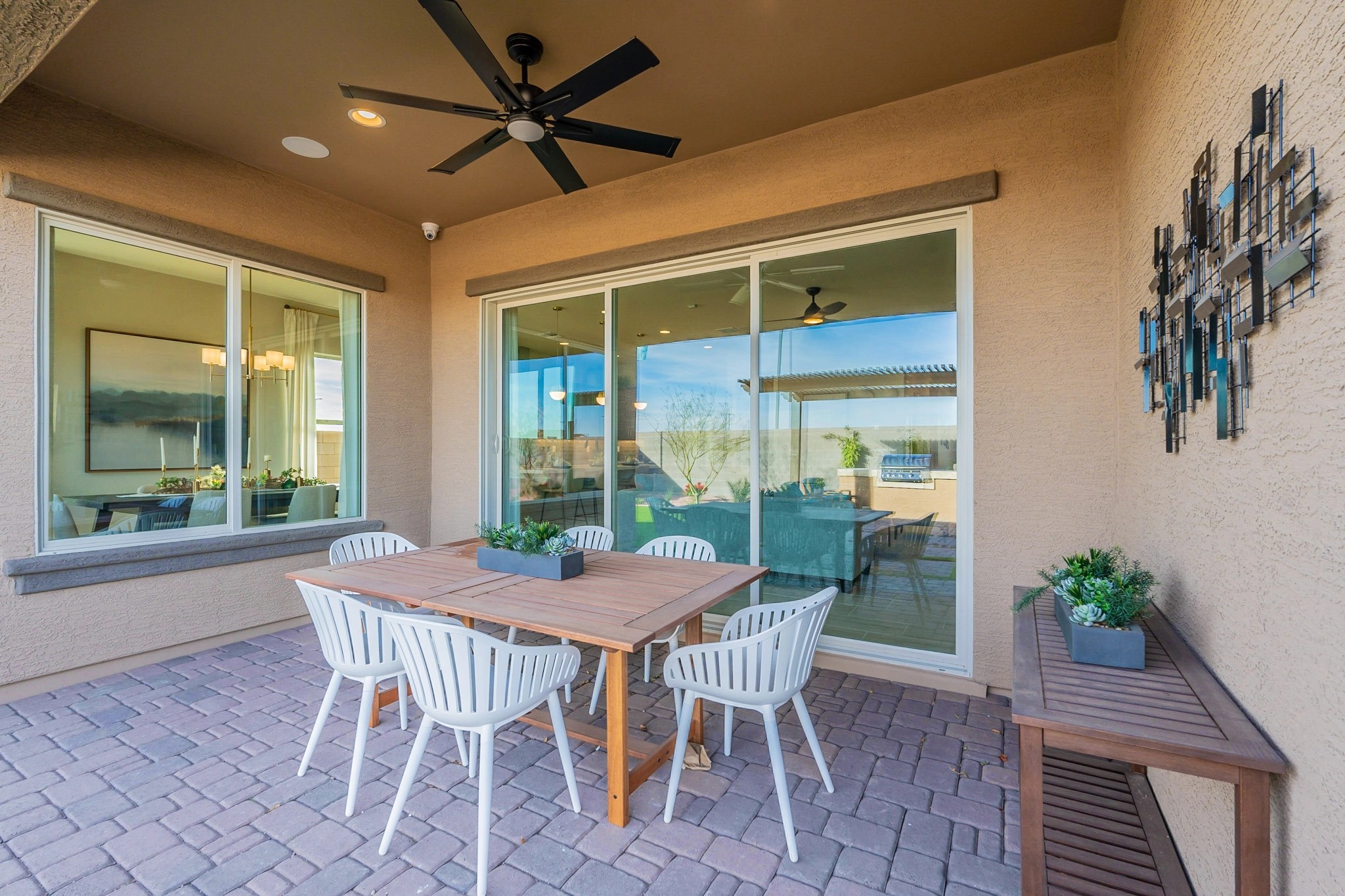 Luxurious Patio with Ceiling Fan in Arroyo Seco Hacienda Modern patio with wooden table, ceiling fan, large windows, and art in Hacienda, Arroyo Seco community.