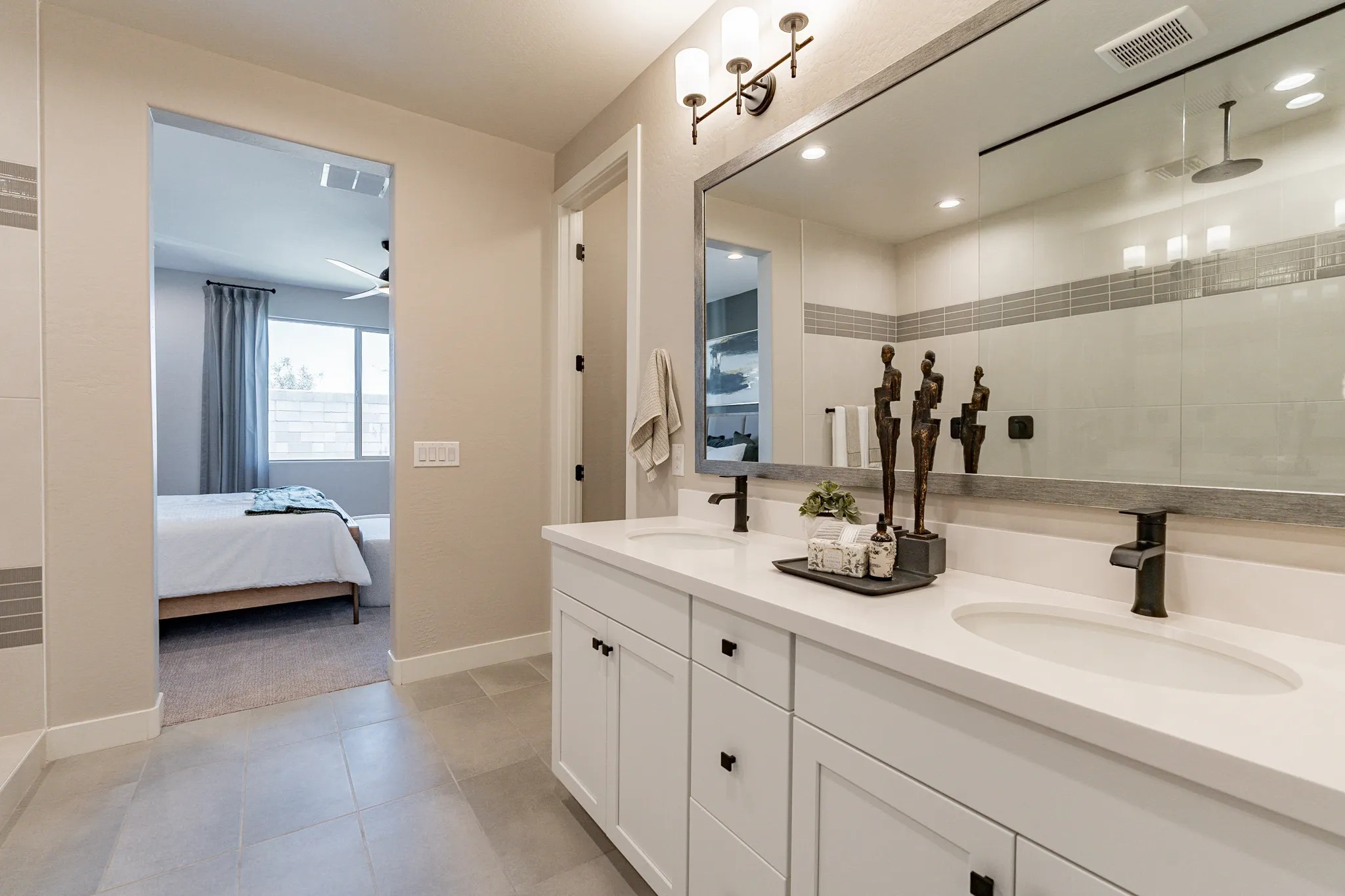 Sienna Park Luxury Bathroom with Dual Sinks and Modern Fixtures Elegant bathroom in Sienna Park with dual sinks, large mirror, modern fixtures, and view into bedroom. Neutral tones.