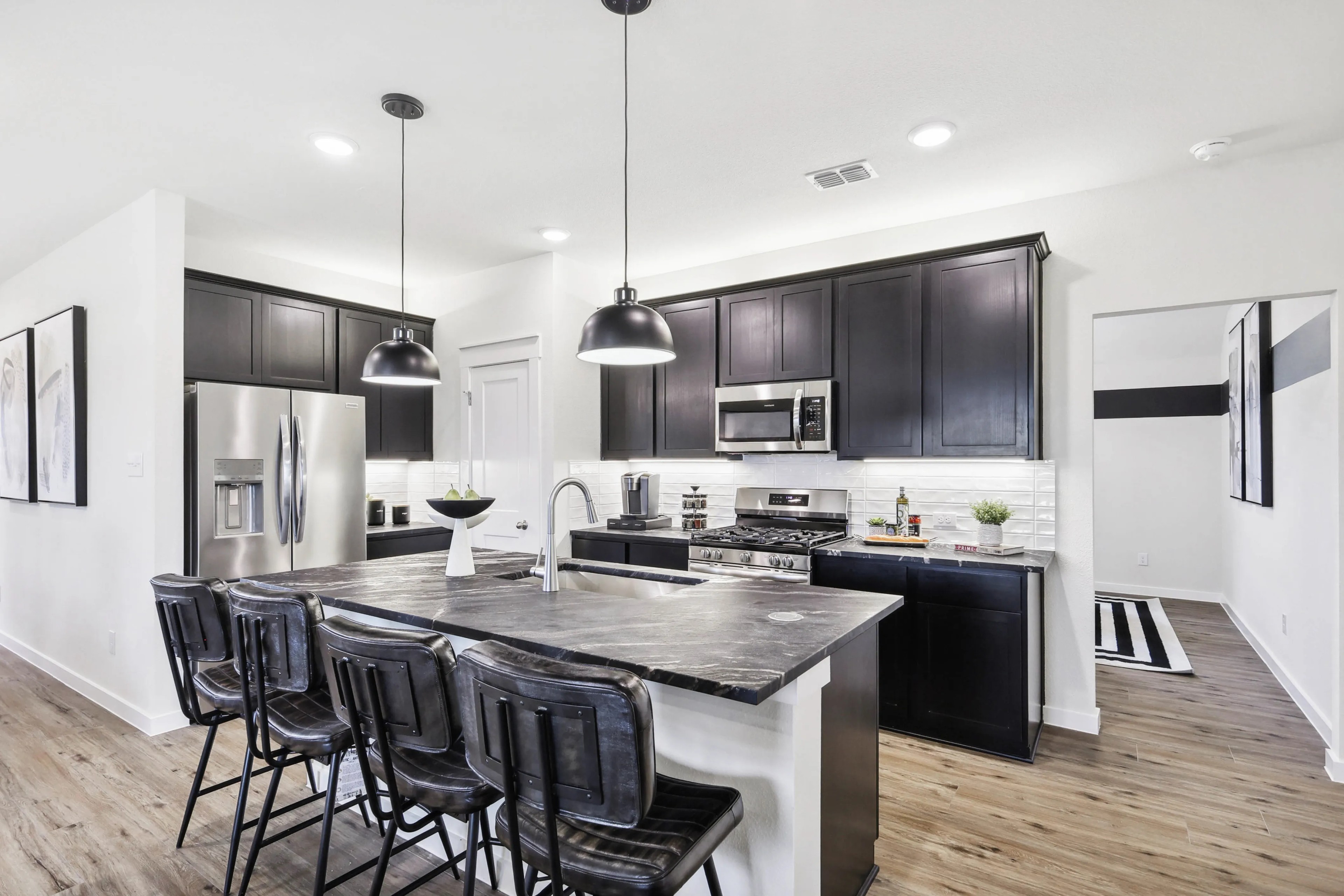 Modern Kitchen with Dark Cabinets and Island in Simpson Crossing Elegant kitchen island, dark cabinets, stainless steel appliances, in Simpson Crossing, modern design.
