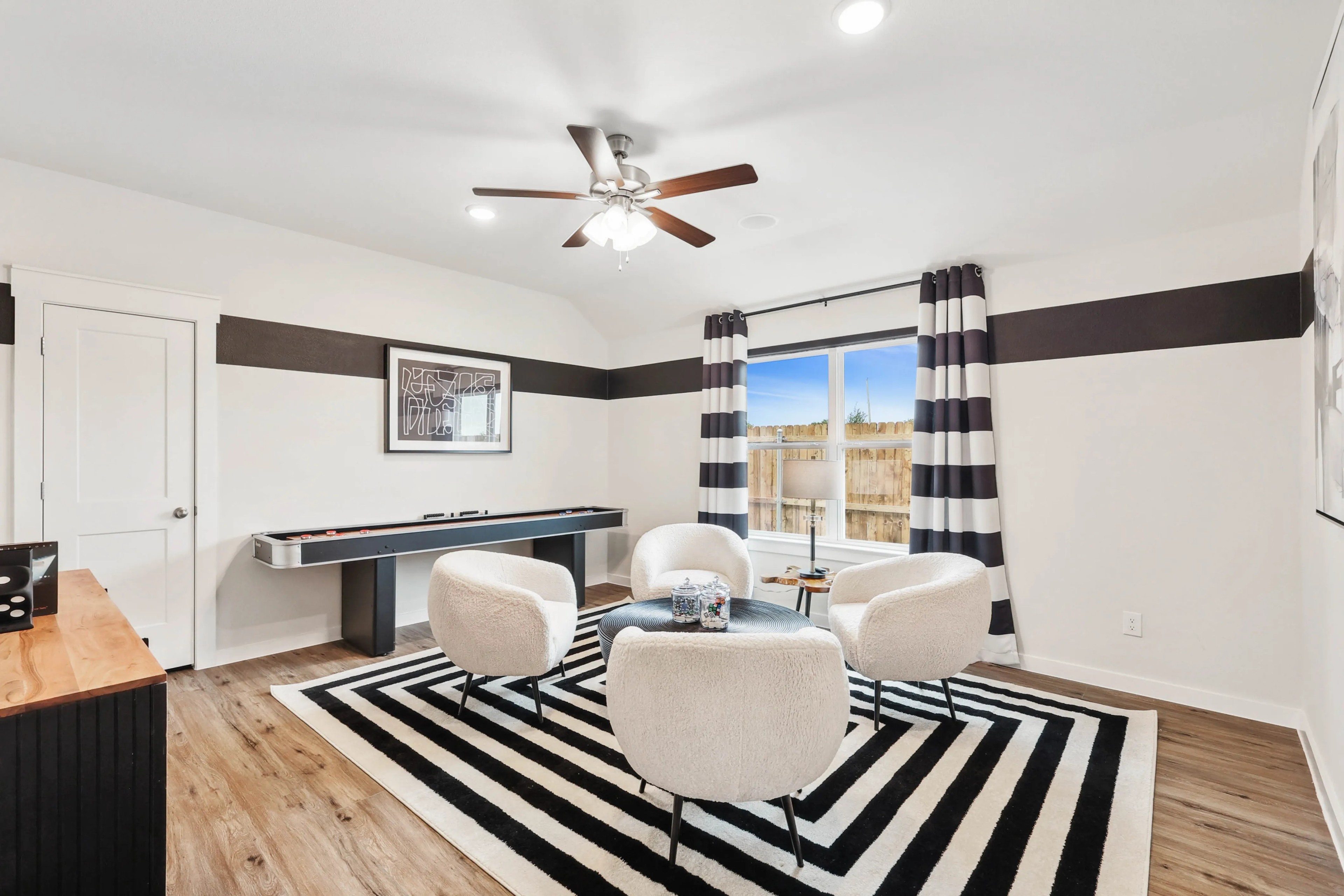 Simpson Crossing Living Room with Modern Decor and Stylish Design Modern living room with white chairs, striped rug, large window in Simpson Crossing.