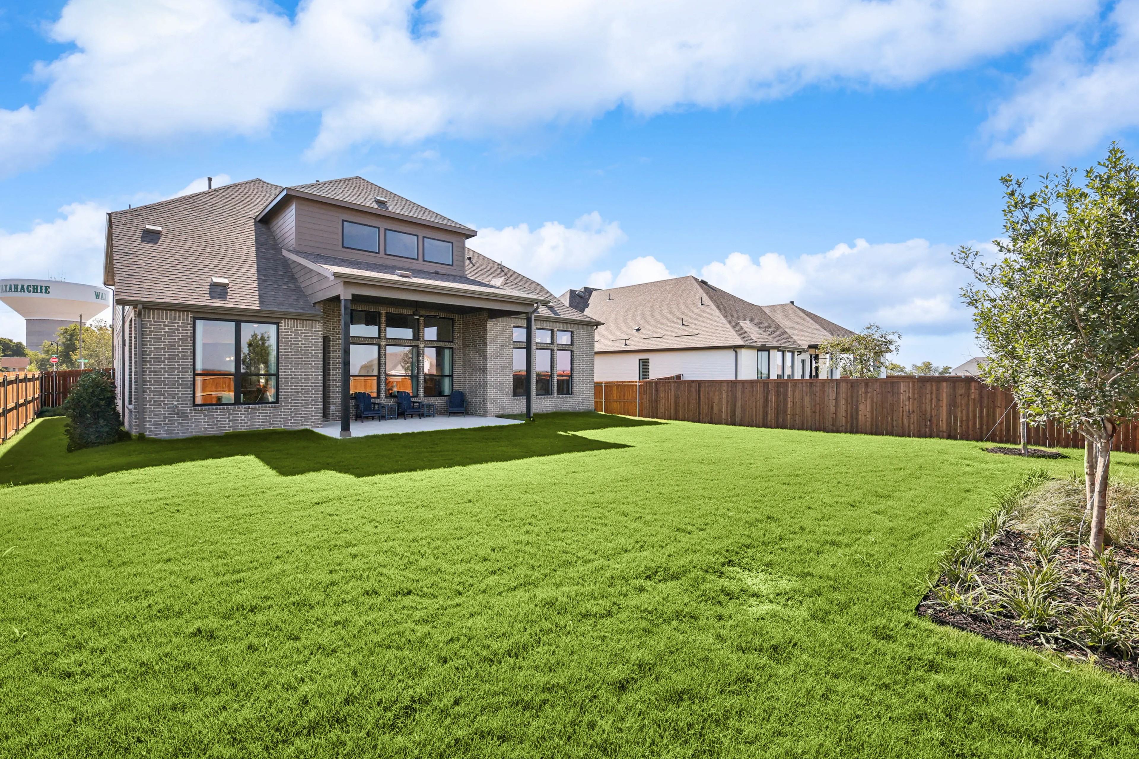 Elegant Brick Home in Ridge Crossing, Waxahachie Spacious brick home with large windows, gabled roof, and lush lawn in Waxahachie. Ridge Crossing community.