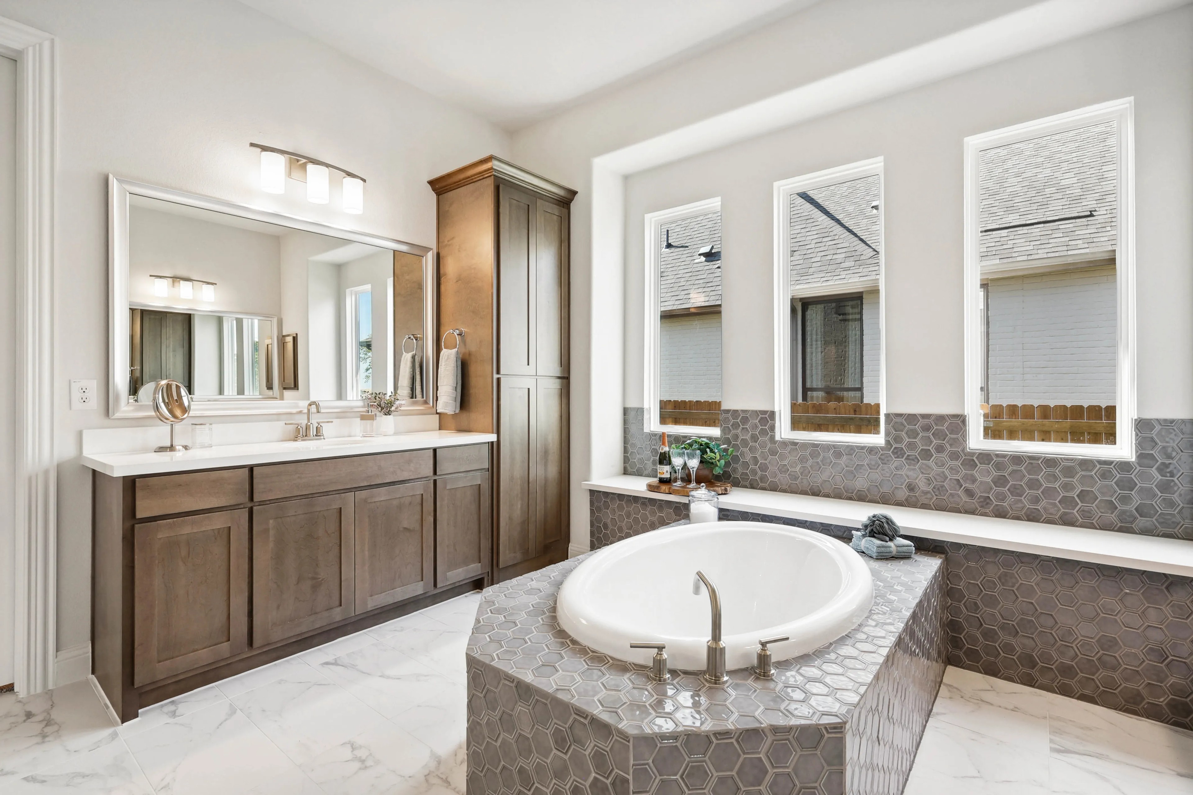 Ridge Crossing Bathroom with Oval Tub and Wooden Cabinets Luxurious bathroom with oval tub, hex tile, large mirrors, wooden cabinets in Ridge Crossing.