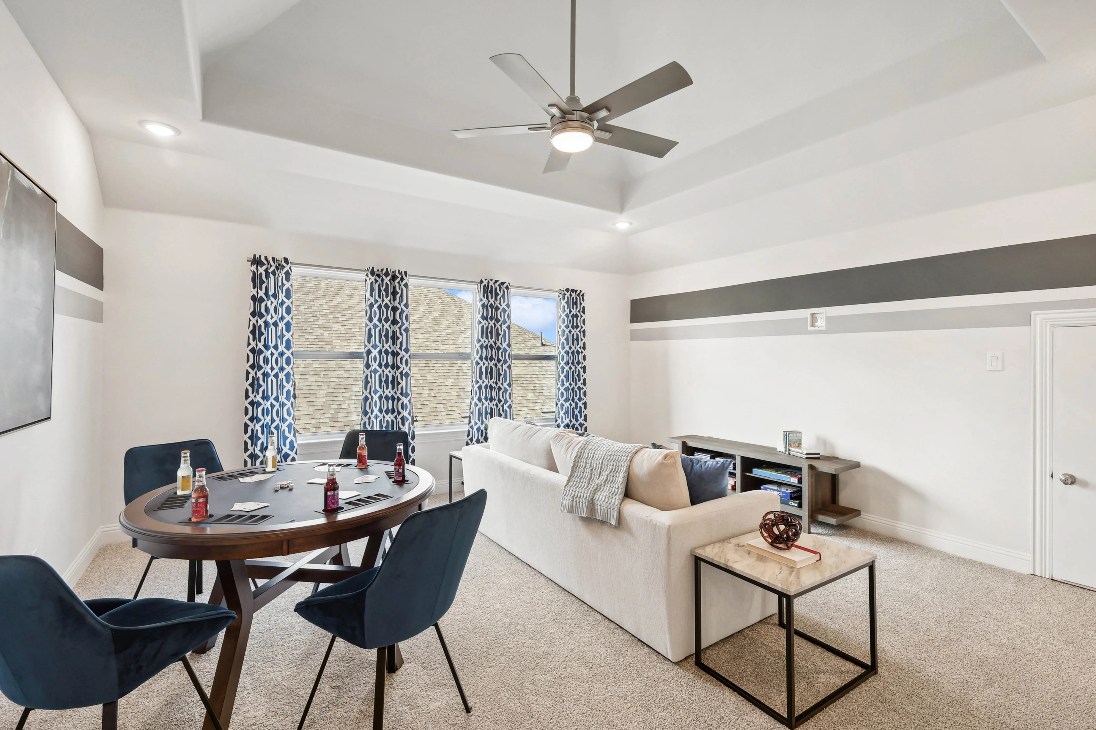 Ridge Crossing Luxury Living Room with Poker Table and Modern Decor Elegant Ridge Crossing living room with poker table, blue chairs, modern ceiling fan, geometric curtains.