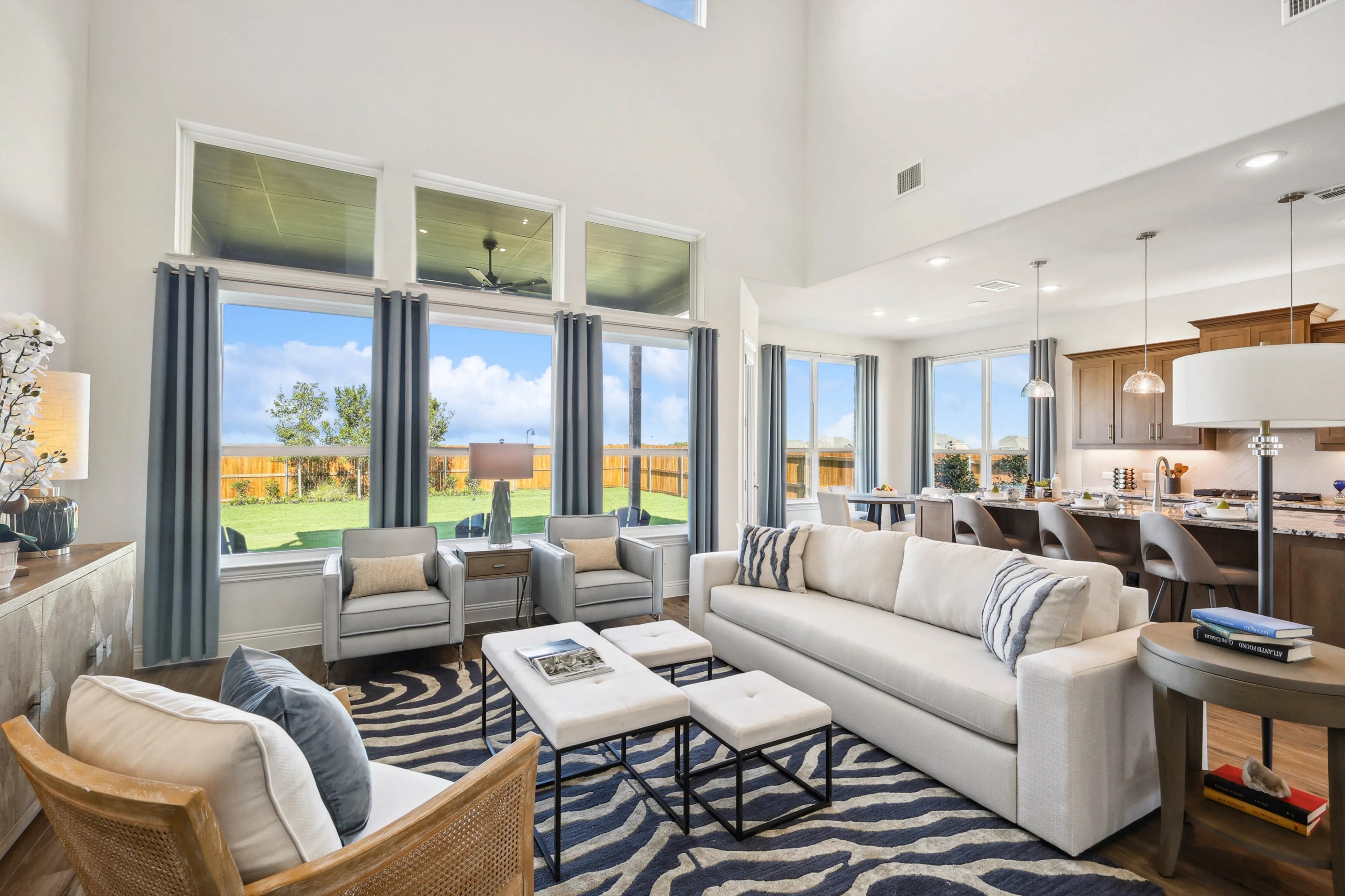 Ridge Crossing Luxury Living Room with Modern Decor and Open Kitchen Spacious Ridge Crossing living room with tall ceilings, large windows, modern decor, and open kitchen layout.