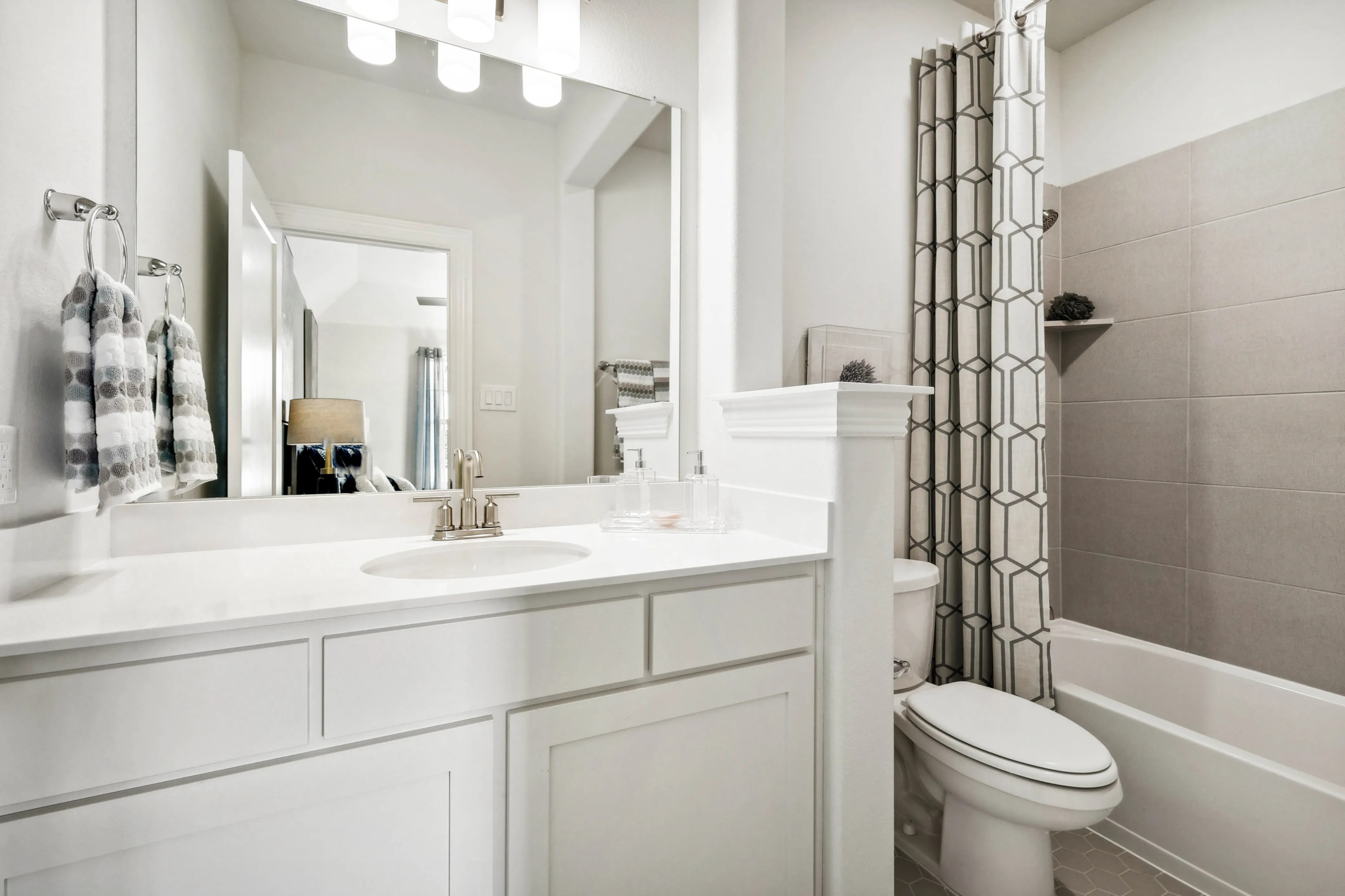 Ridge Crossing Bathroom Design with White Vanity and Modern Features Modern bathroom with white vanity, geometric shower curtain, located in Ridge Crossing community.