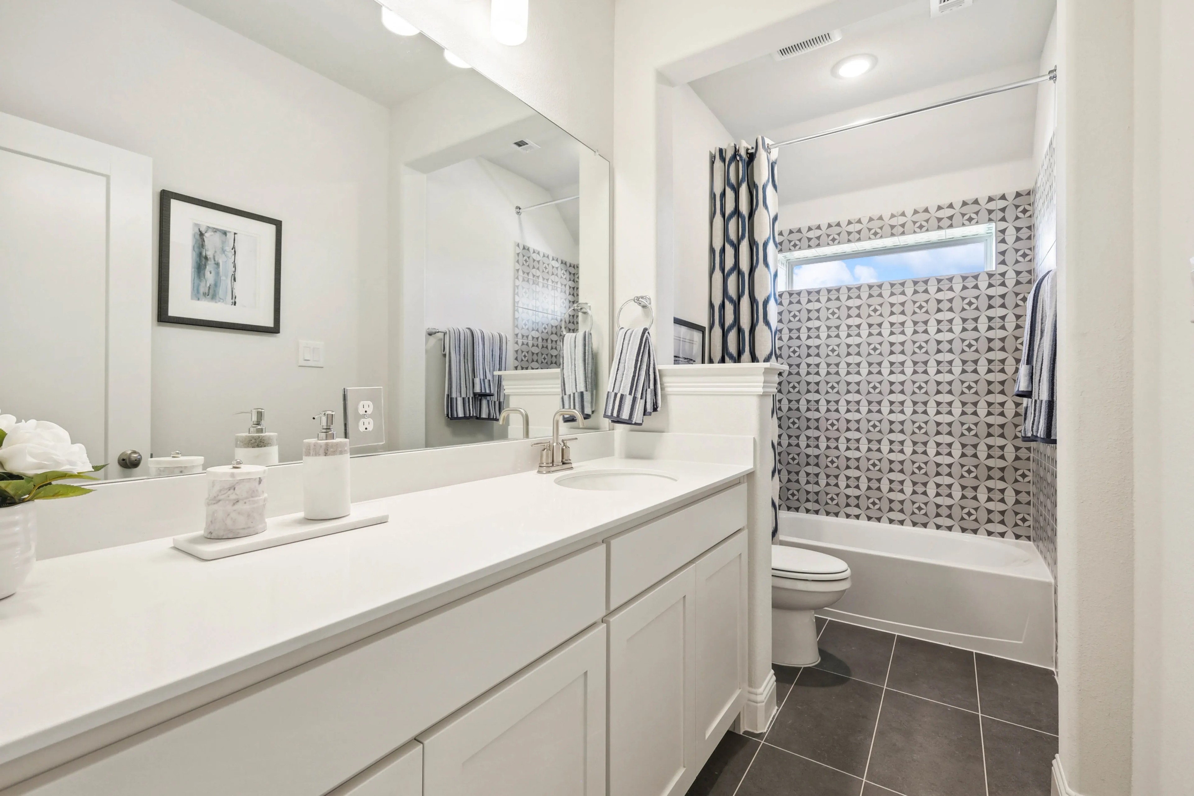 Contemporary Bathroom Design in Ridge Crossing Community Modern bathroom with geometric tile, sleek vanity, and large mirror. Ridge Crossing community.
