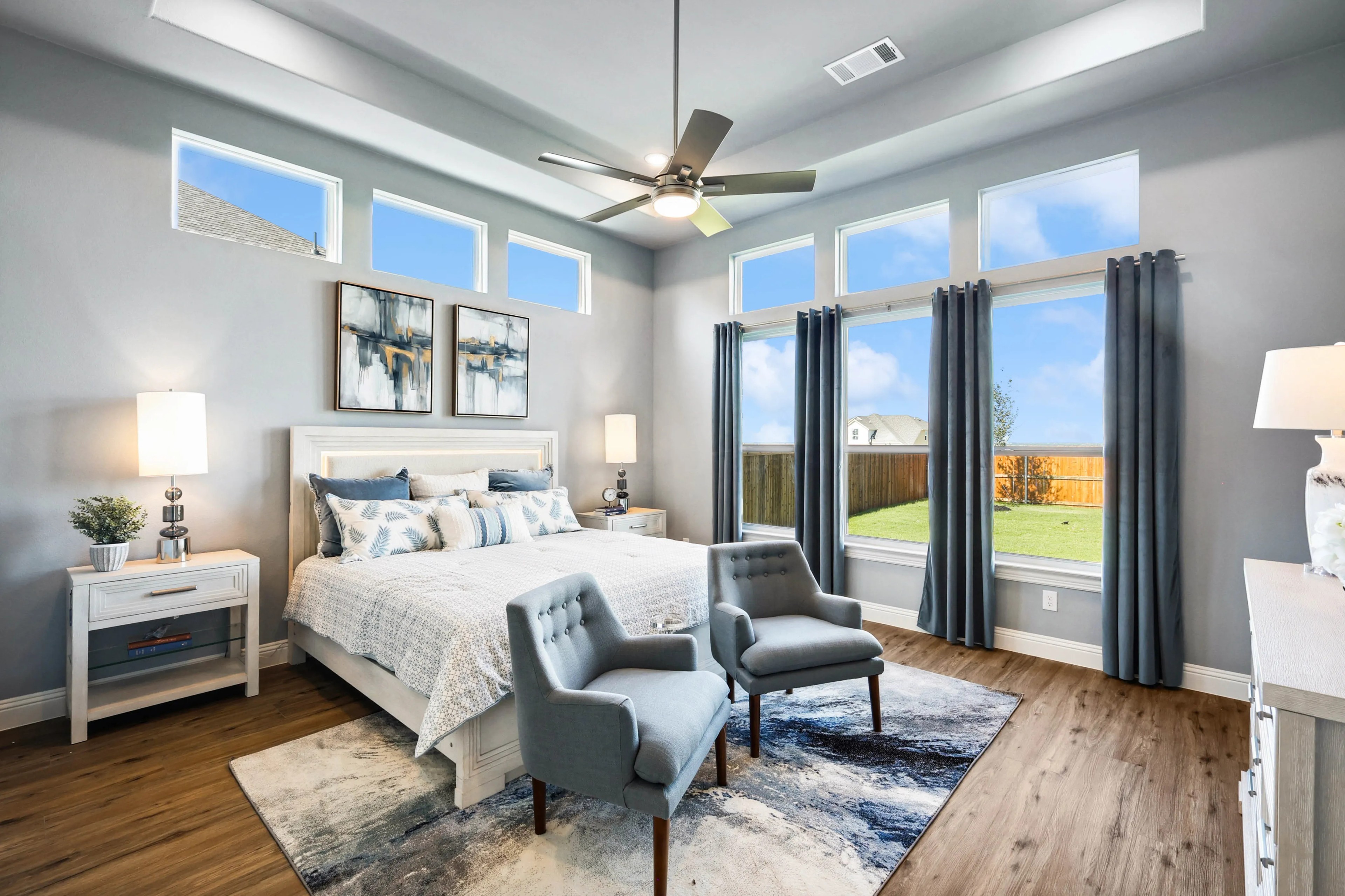 Elegant Bedroom Design with High Windows in Ridge Crossing Community Modern bedroom with high windows, hardwood floors, and stylish decor in Ridge Crossing community.