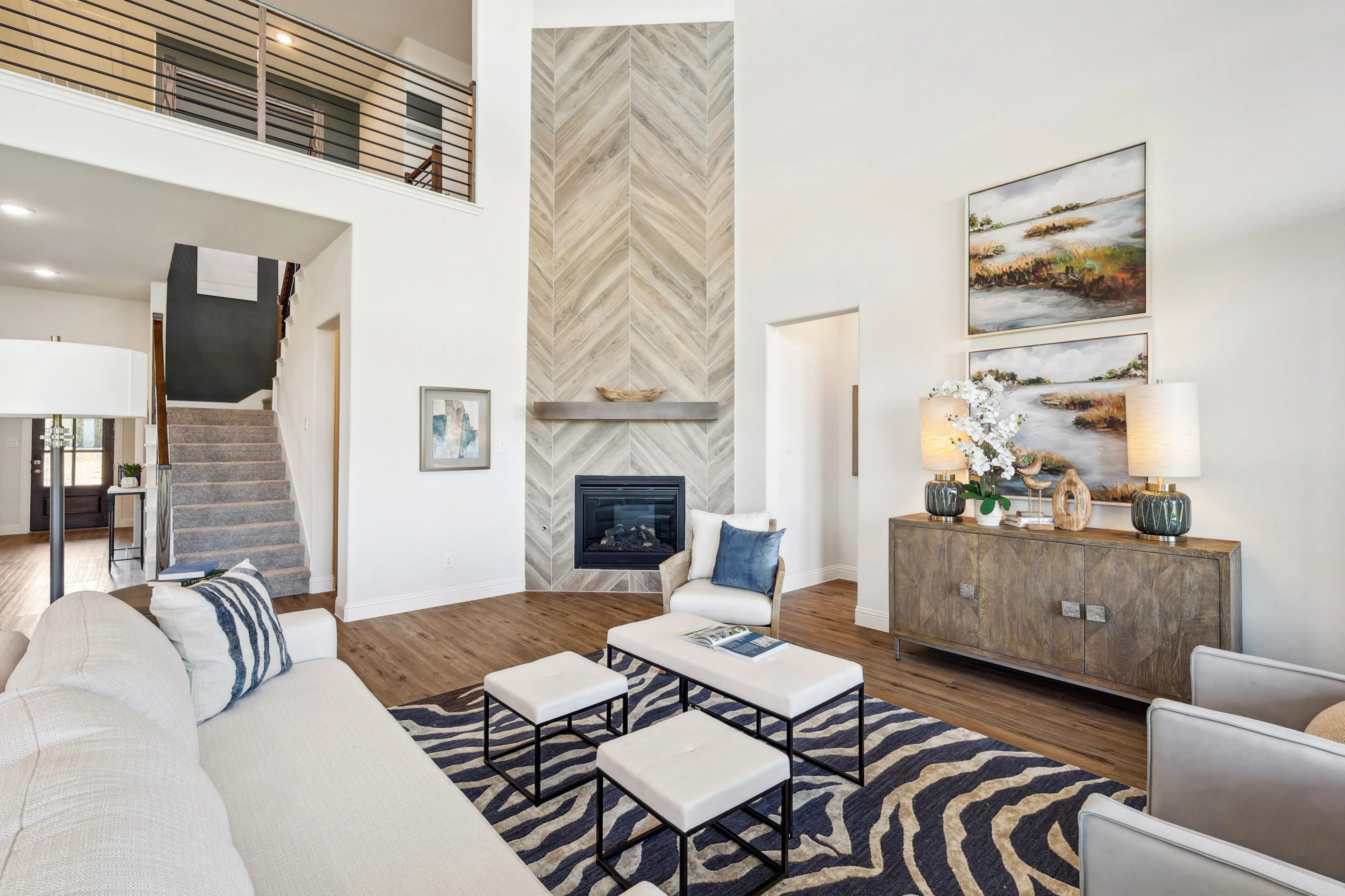 Elegant Living Room in Ridge Crossing Featuring Herringbone Fireplace Spacious living room with herringbone fireplace, stylish decor, and staircase in Ridge Crossing.