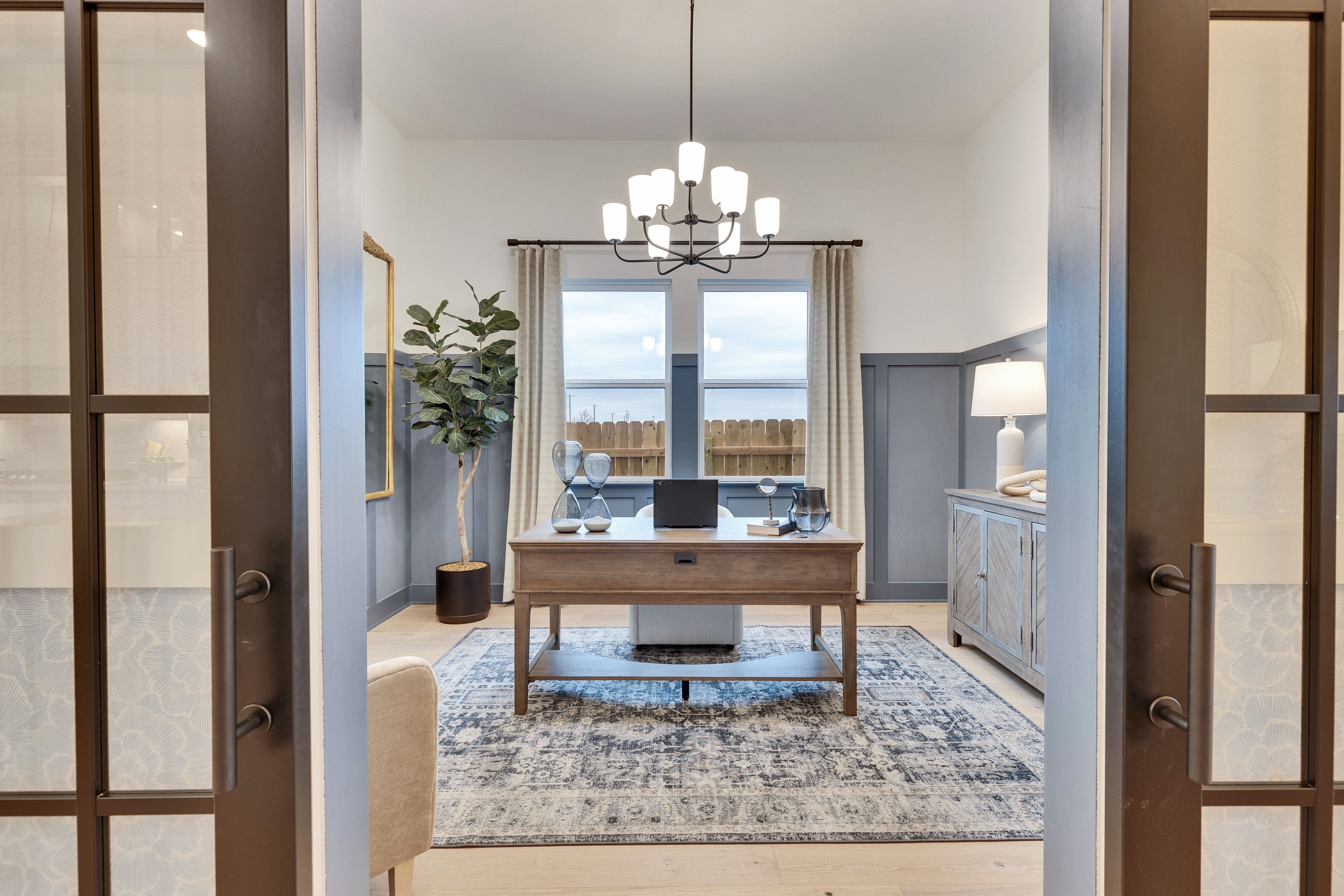 Sophisticated Home Office in Spring Creek, Texas Elegant home office with wood desk, sleek chandelier, modern decor in Spring Creek, Texas.