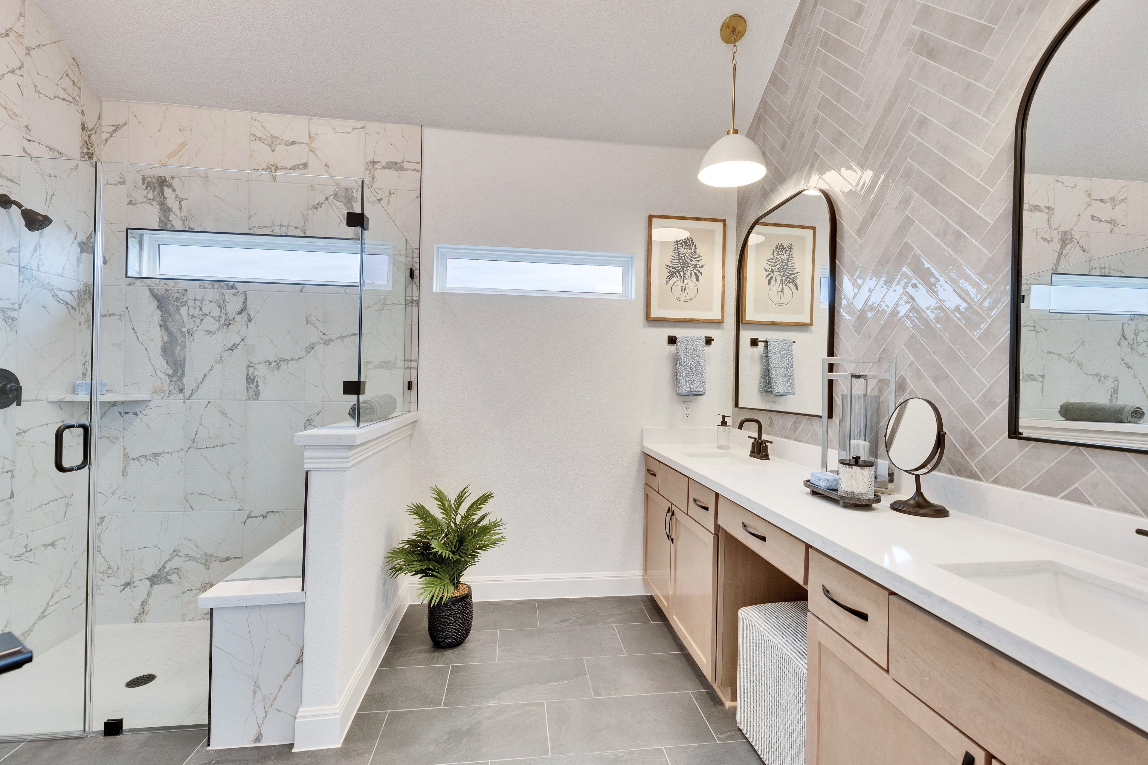 Spring Creek Bathroom with Marble and Herringbone Tile Design Luxurious bathroom with marble shower, herringbone tile wall, dual sinks, elegant lighting in Spring Creek.