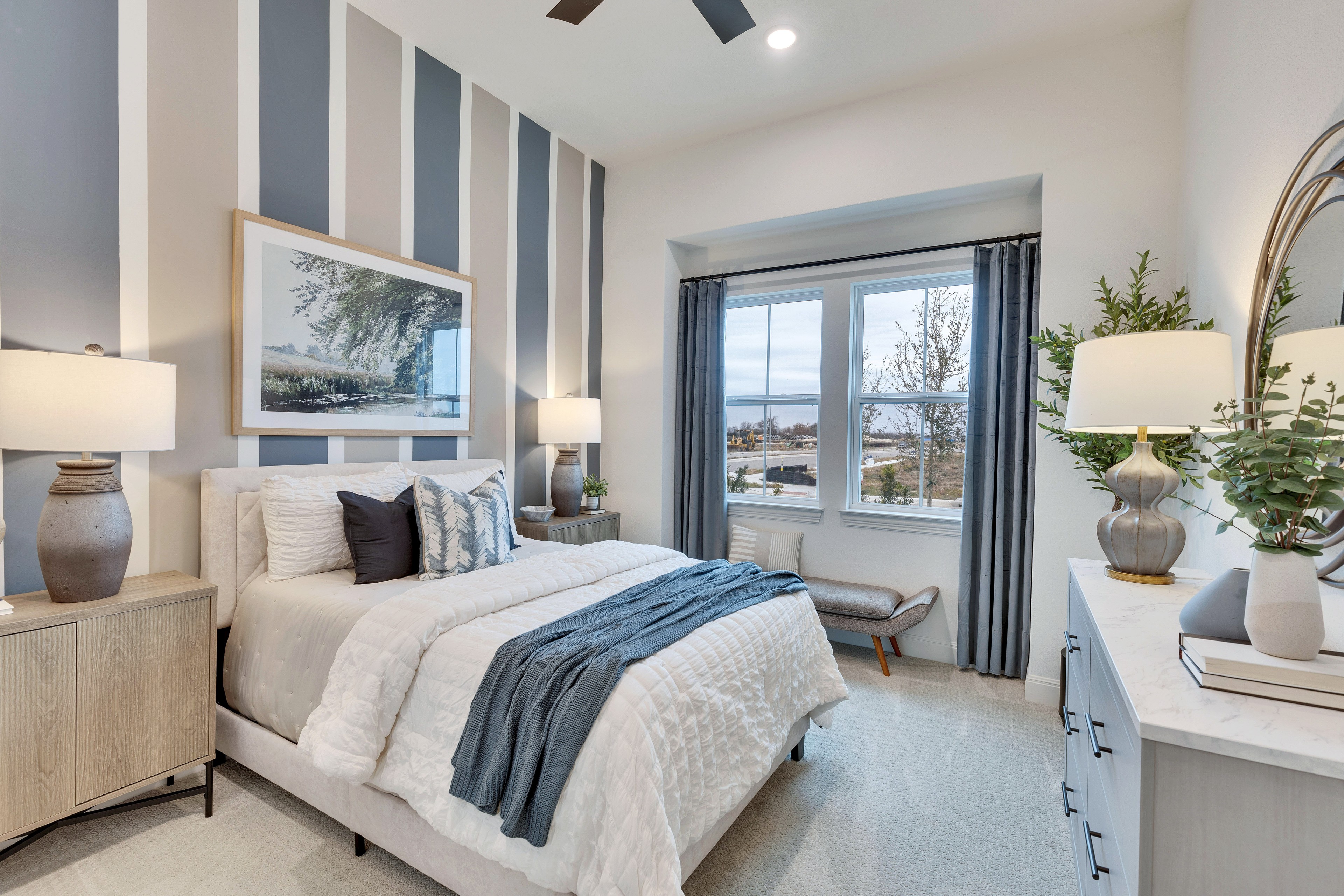 Luxurious Bedroom with Striped Accent Wall in Spring Creek Community Elegant bedroom with striped accent wall, large window view, and plush bed in Spring Creek community.