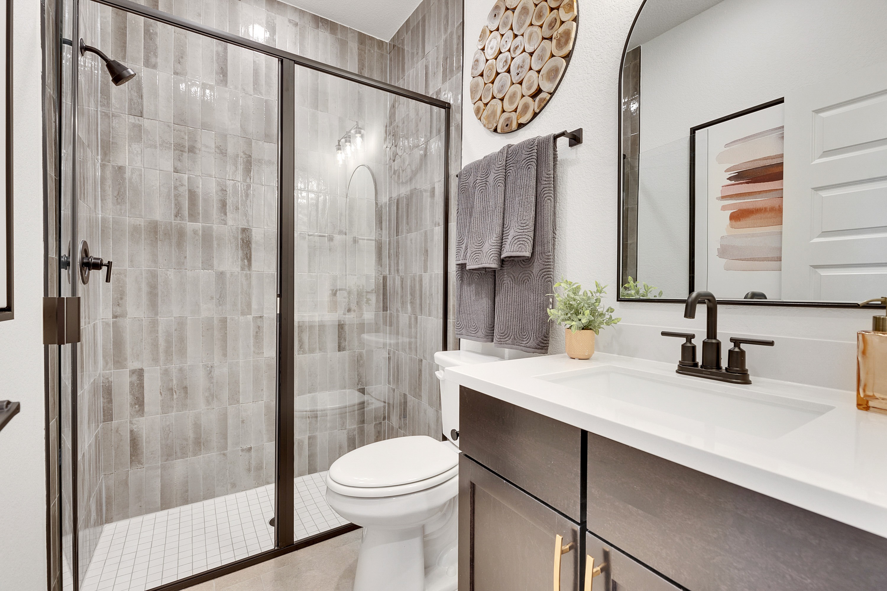 Modern Bathroom with Glass Shower in Spring Creek Community Modern bathroom with glass shower, textured tile walls, dark vanity, elegant fixtures in Spring Creek.