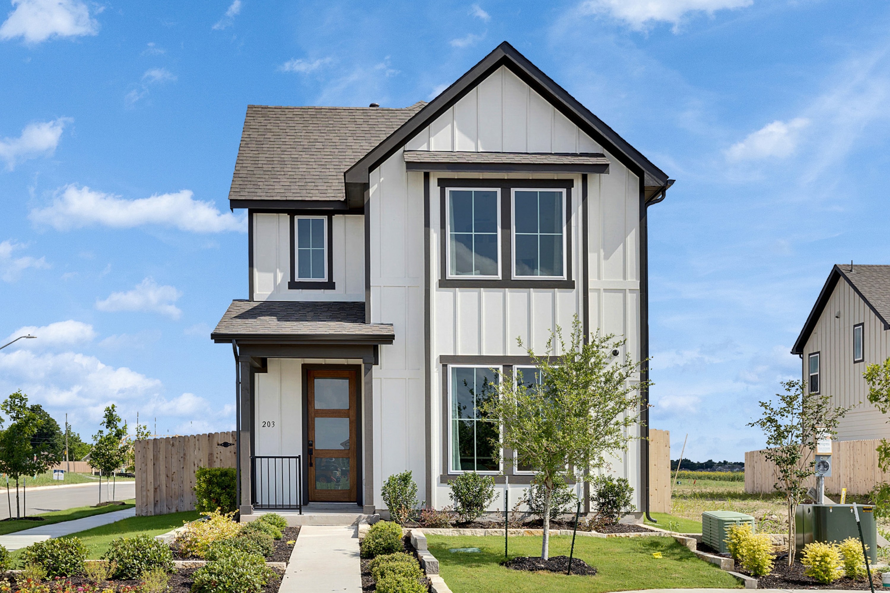 Modern Two-Story Home in Spring Creek with Large Windows Modern two-story home in Spring Creek with white facade, large windows, and landscaped garden.