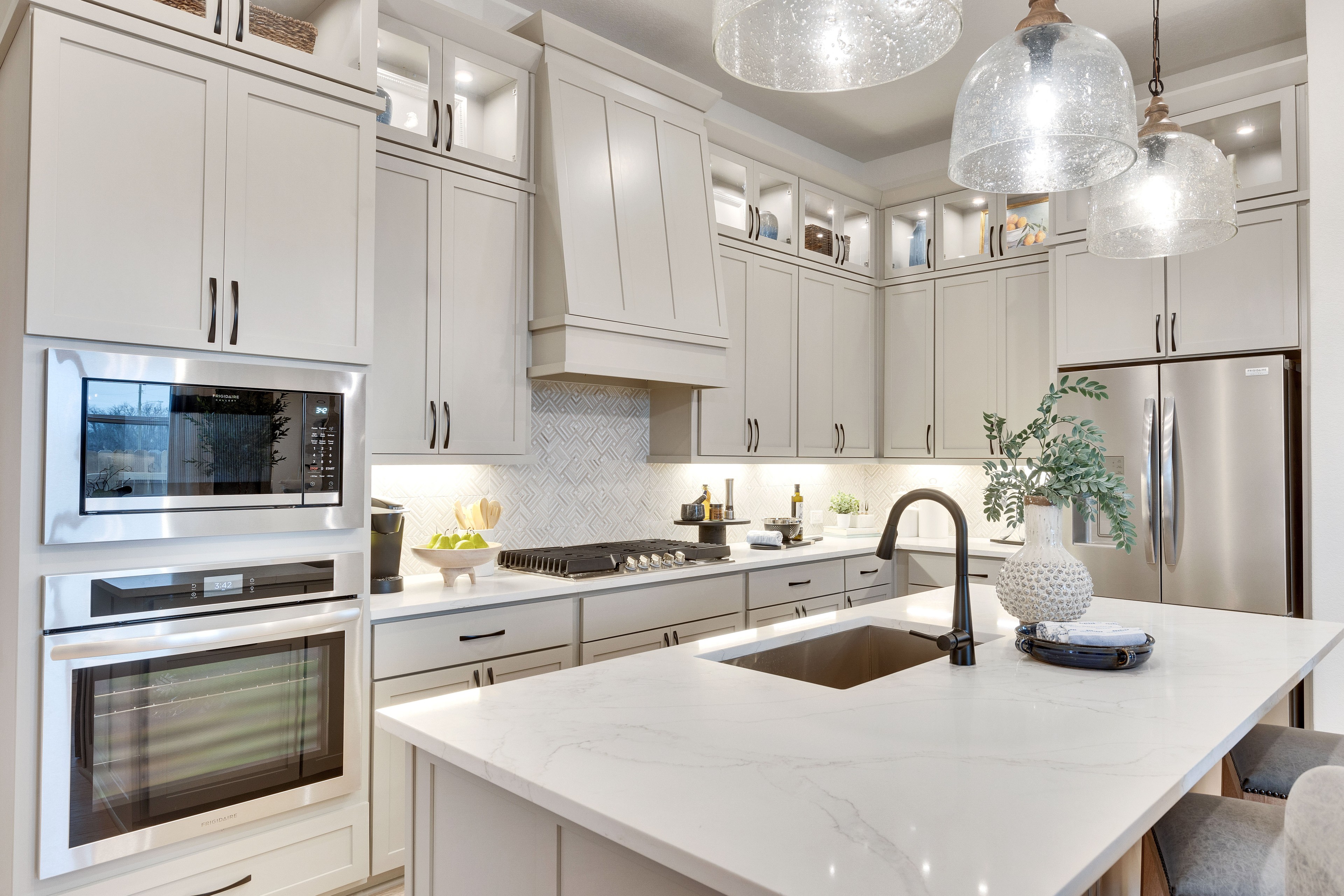 Modern Kitchen with White Cabinetry in Spring Creek Home Elegant modern kitchen with white cabinetry, marble counters, stainless appliances in Spring Creek home.
