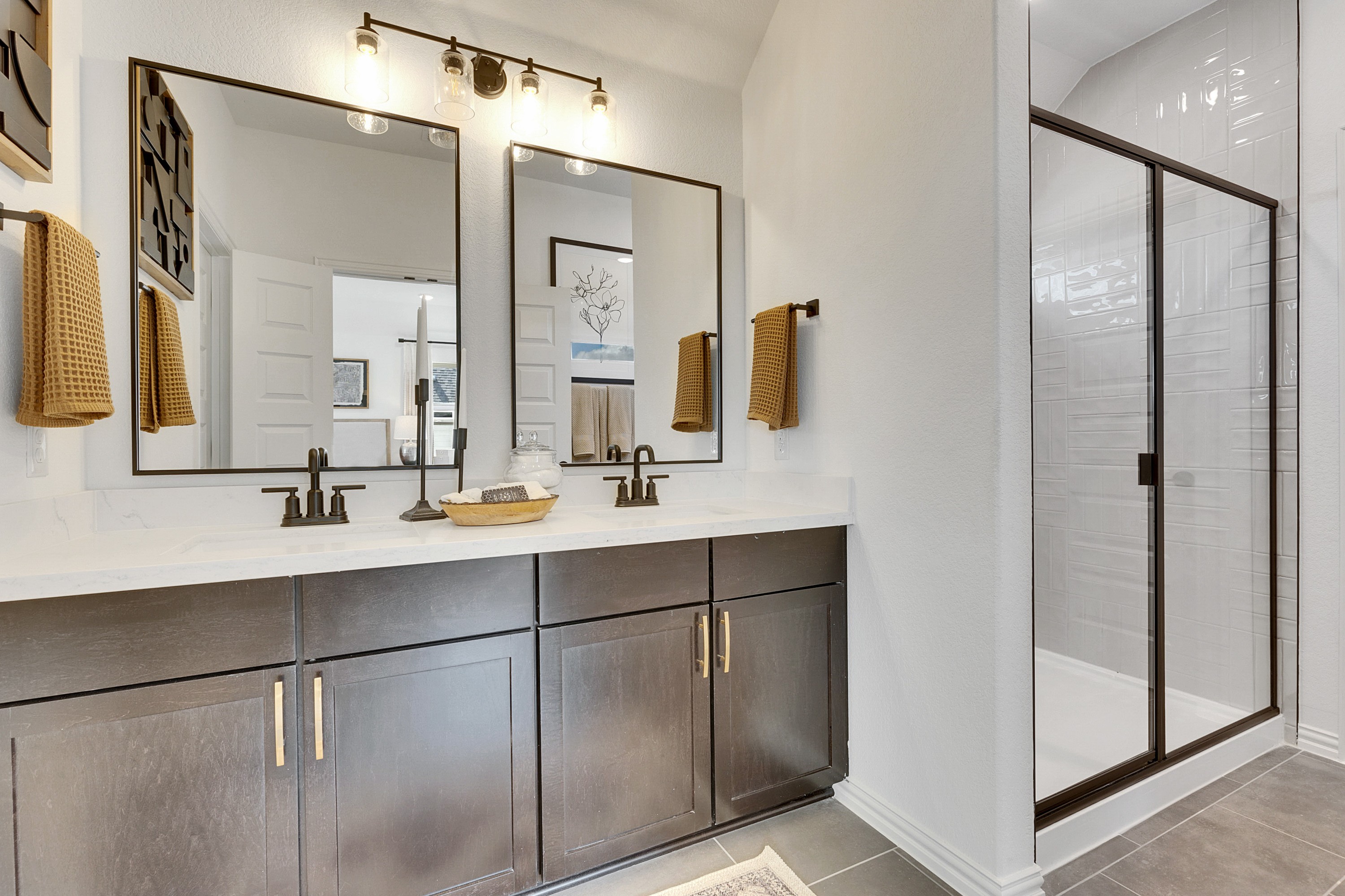 Modern Bathroom with Dual Sinks in Spring Creek Community Modern bathroom with dual sinks, large mirrors, dark wood cabinets, glass shower in Spring Creek community.