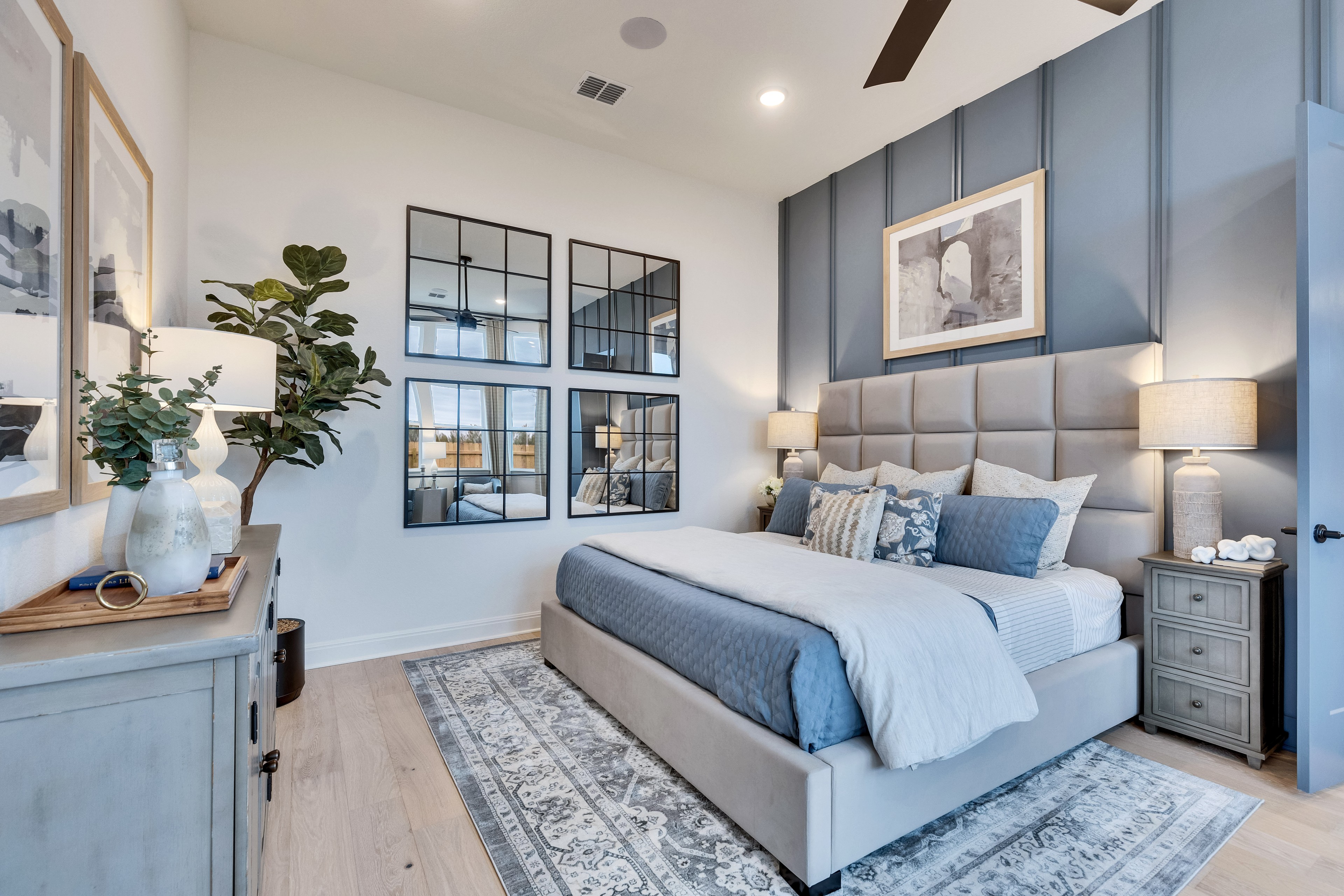 Luxury Bedroom with Tufted Headboard in Spring Creek Community Elegant bedroom with tufted headboard, paneled accent wall, mirrored art in Spring Creek luxury community.