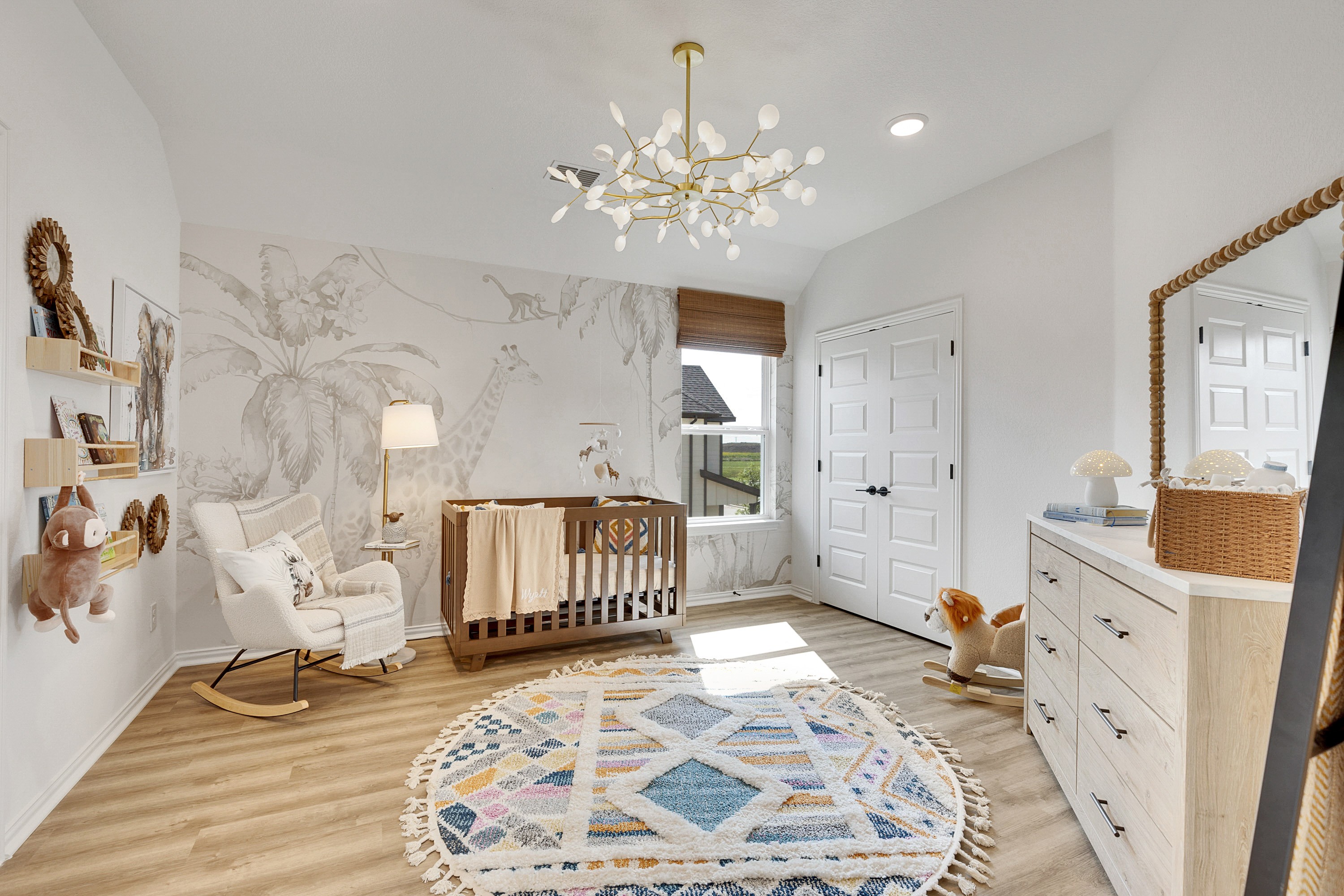 Stylish Nursery with Giraffe Mural and Chic Decor in Spring Creek Modern nursery with giraffe mural, chic chandelier, and crib in Spring Creek. Wooden elements and soft decor feature.