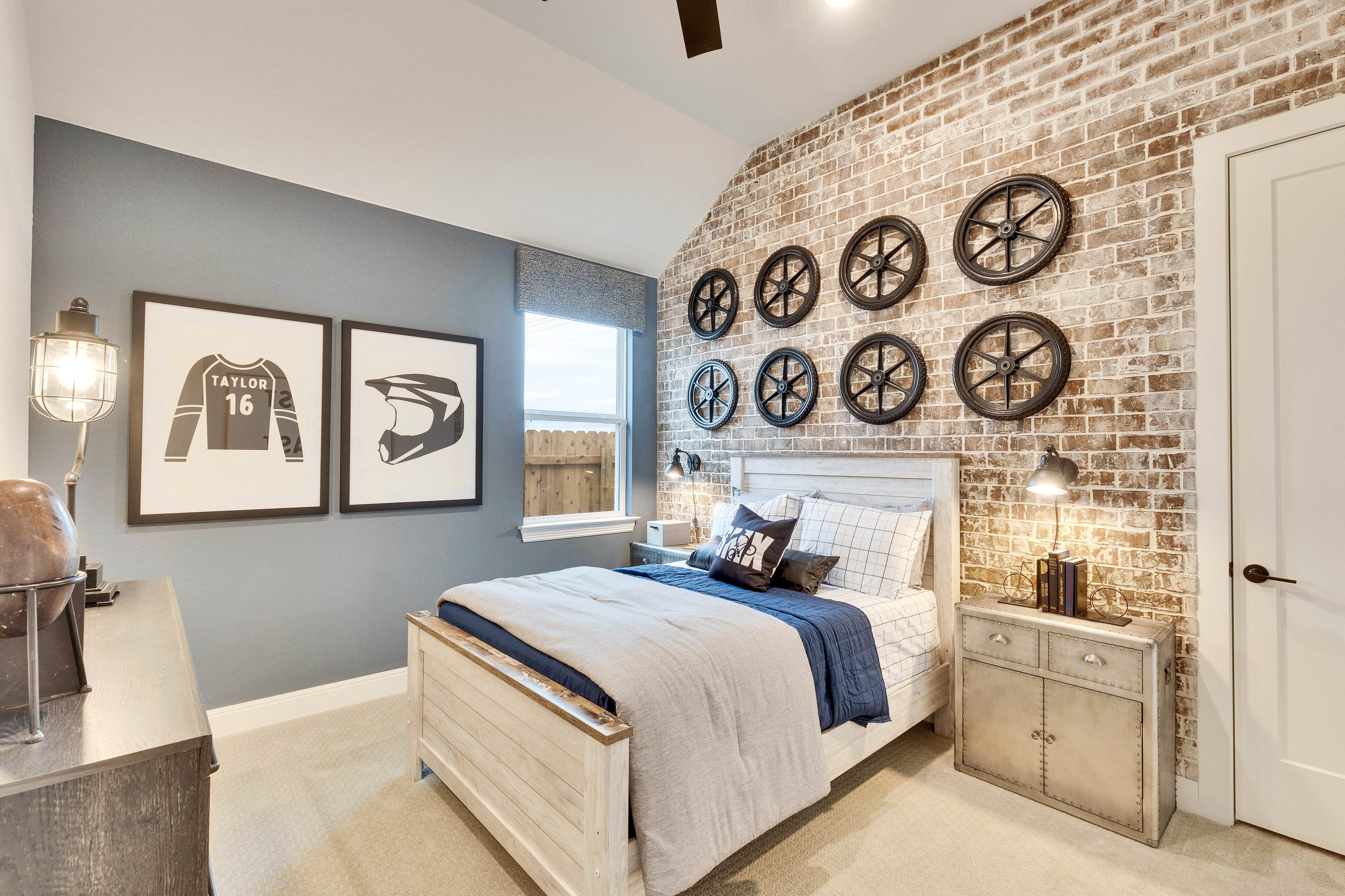 Luxurious Spring Creek Bedroom with Brick Wall and Modern Decor Elegant bedroom with brick accent wall, wheel decor, framed prints, and modern lighting in Spring Creek.