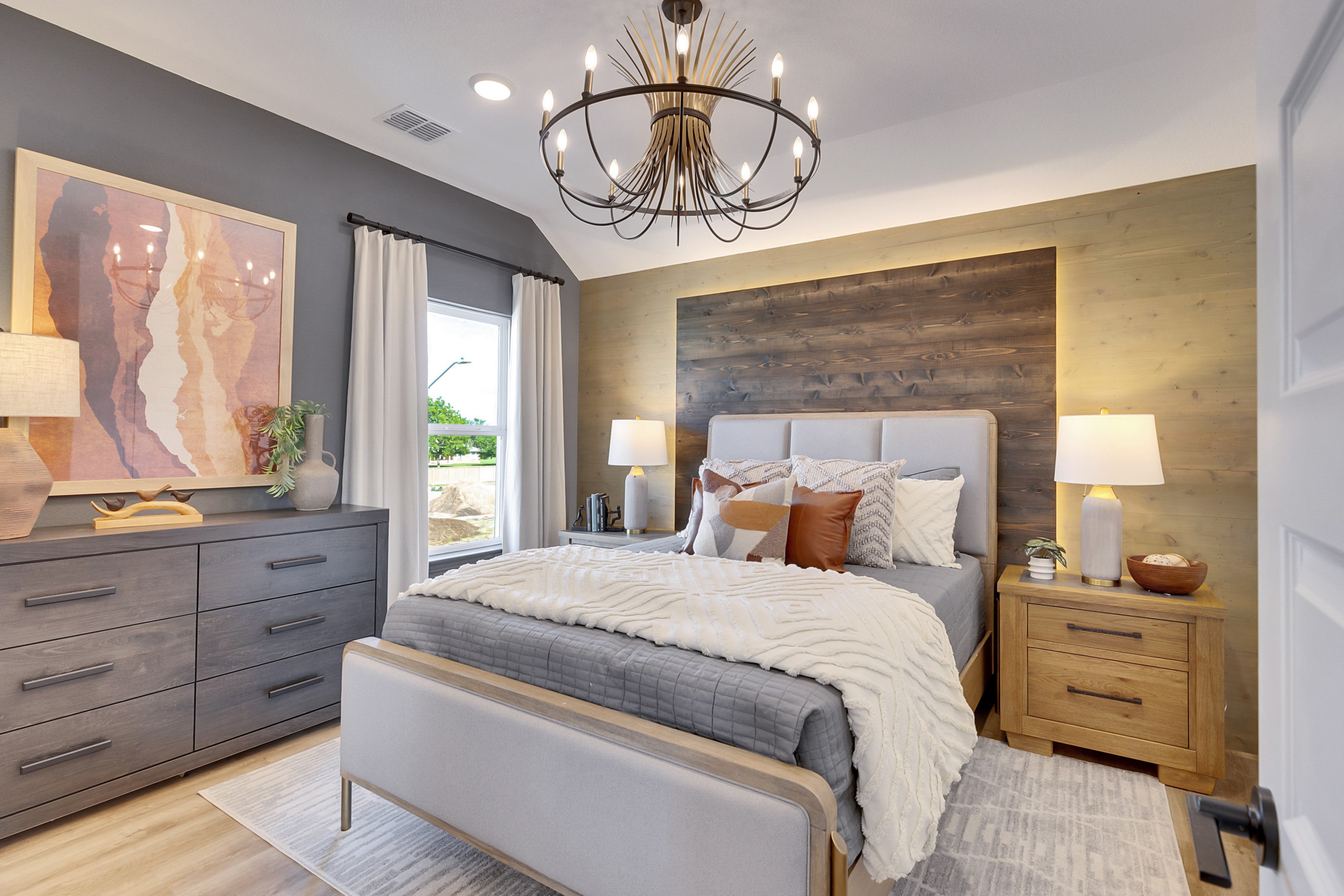 Elegant Bedroom with Chandelier in Spring Creek Community Luxurious bedroom with chandelier, wood accent wall, elegant decor, Spring Creek community.