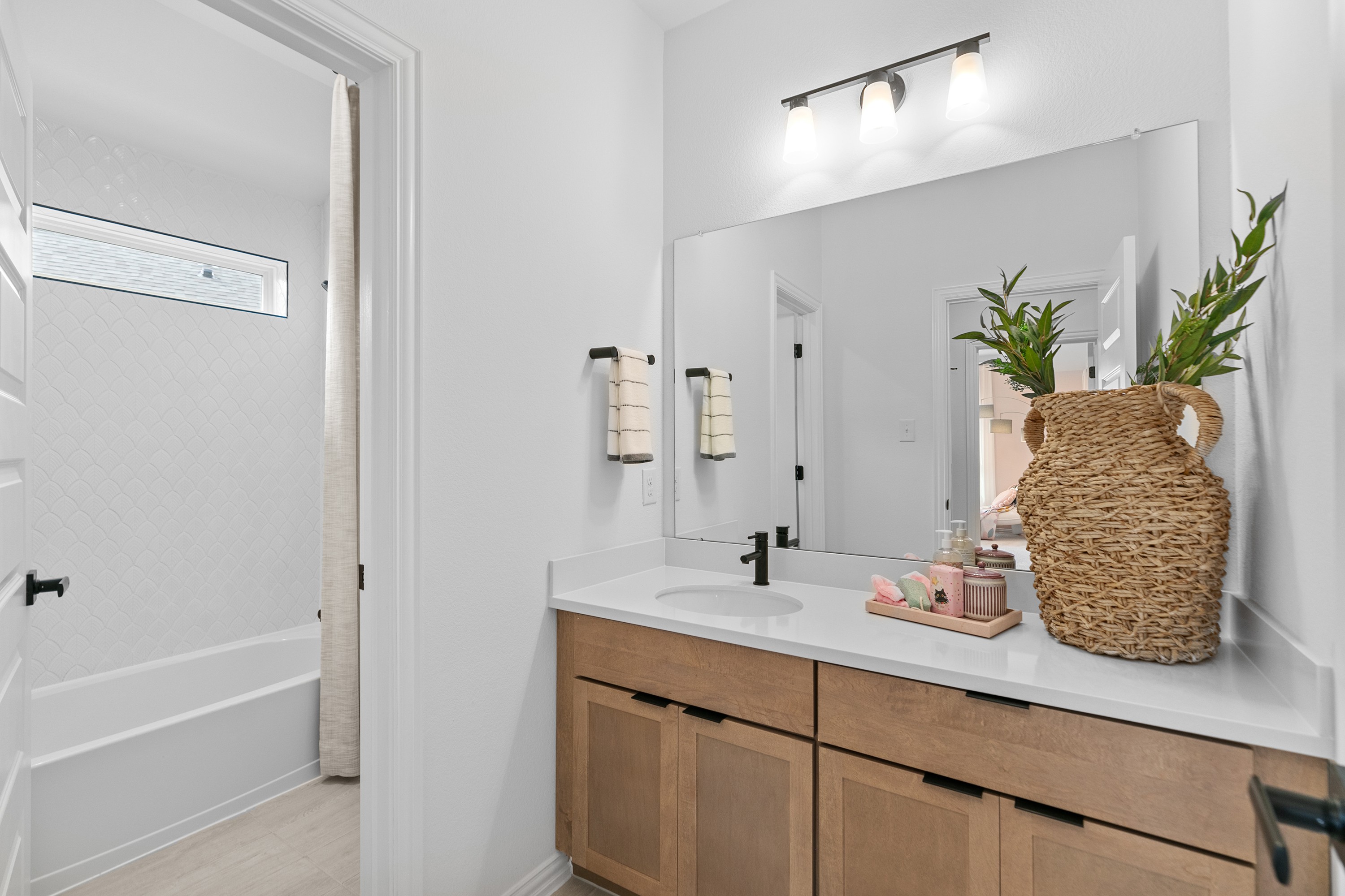River Ranch Modern Bathroom with Wood Vanity and Tile Detailing Modern bathroom in River Ranch with wood vanity, large mirror, basket decor, and tile detailing.