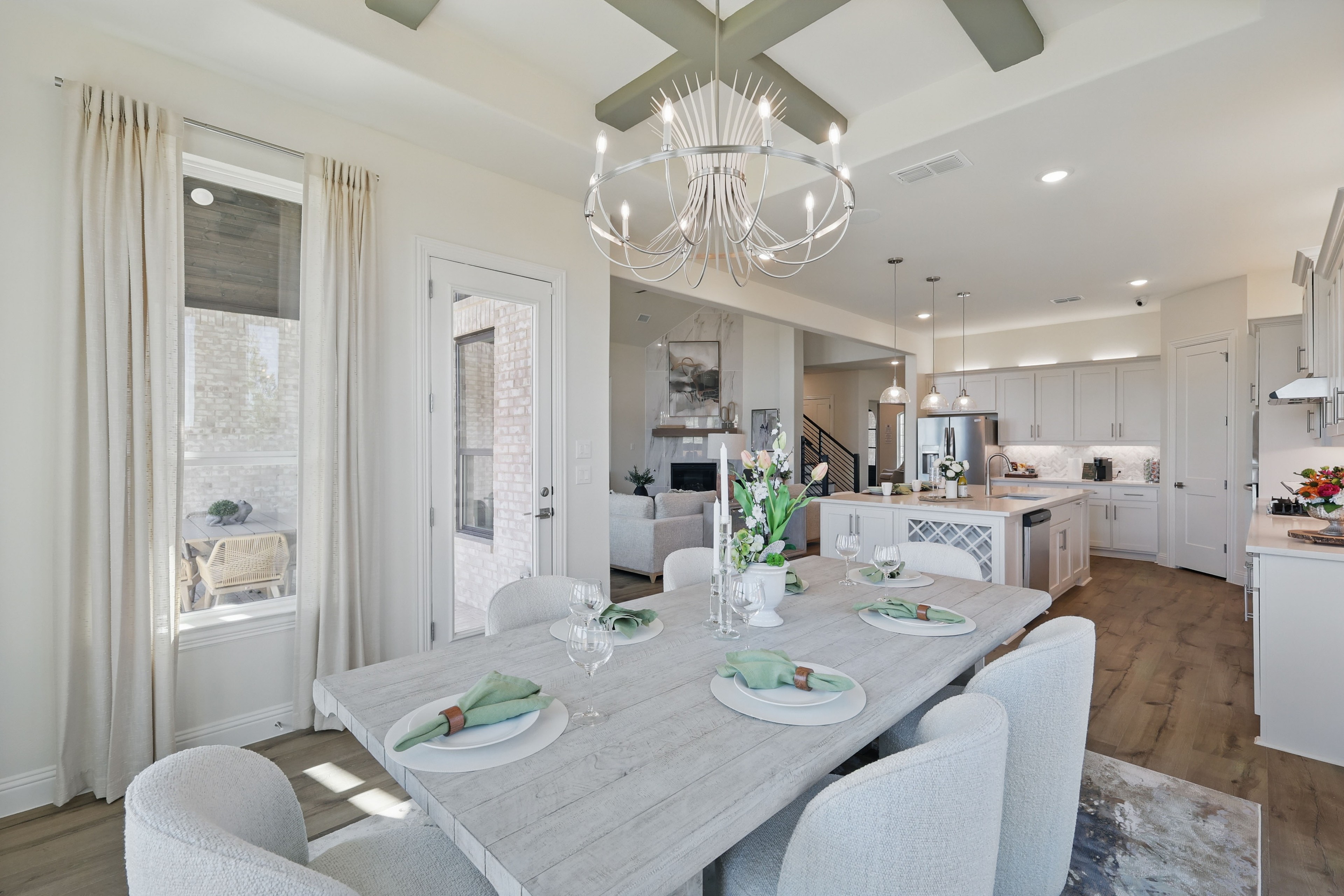 Elegant Dining Room and Kitchen at Rio Vista, Kelly Ranch Modern dining room with light wood table, elegant chandelier, and open kitchen at Kelly Ranch, Rio Vista community.