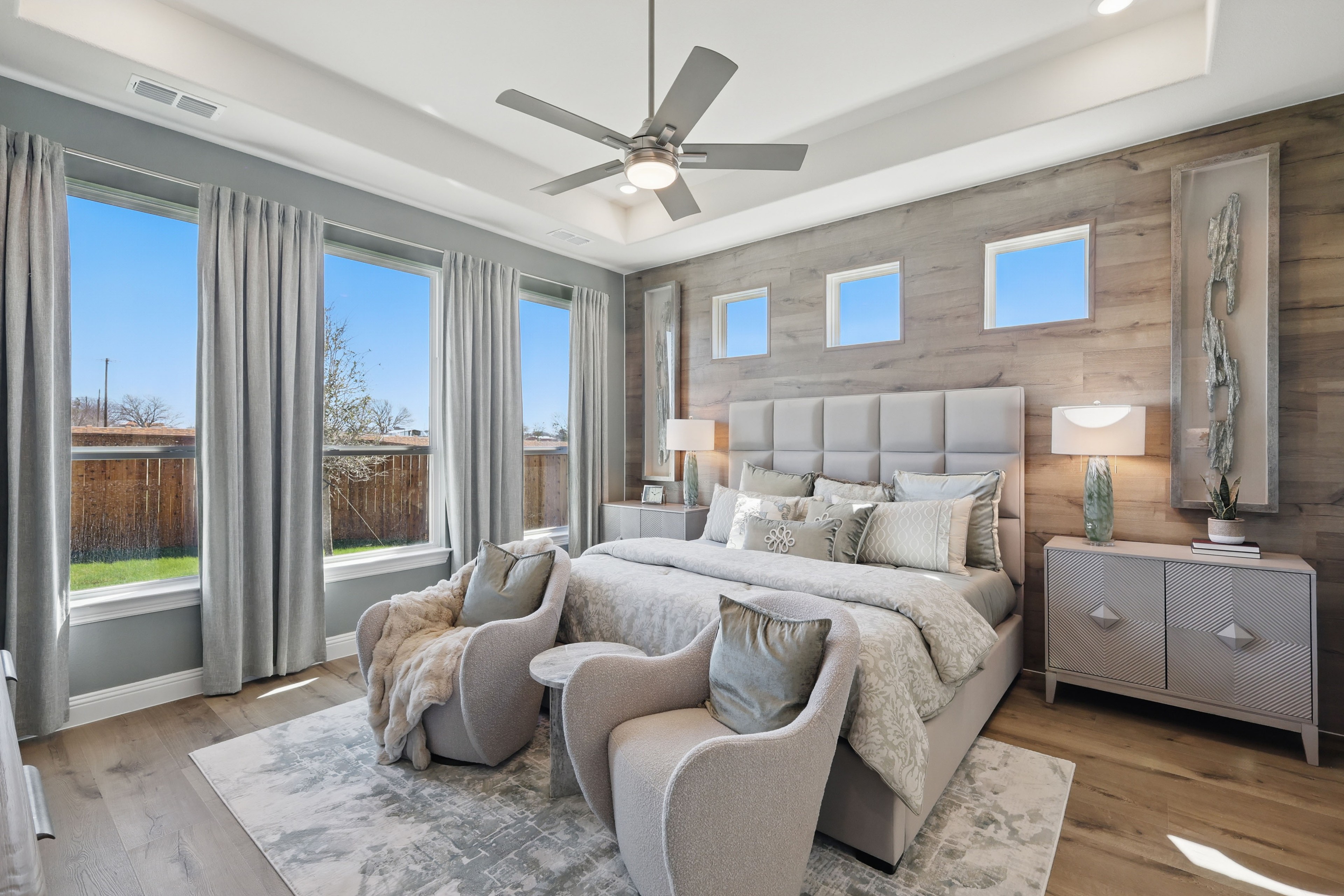 Elegant Bedroom at Rio Vista Kelly Ranch with Wood Accent Wall Luxurious bedroom at Rio Vista Kelly Ranch; wood accent wall, plush bedding, large windows.