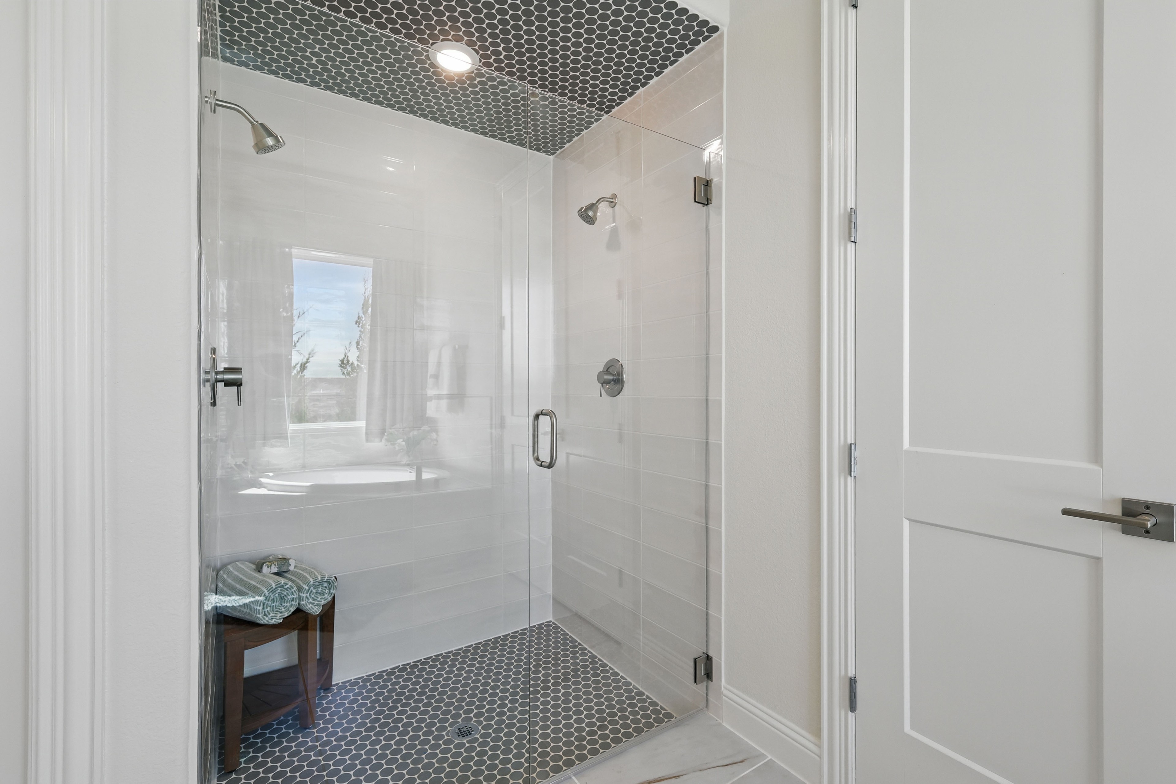 Luxurious Shower Design in Rio Vista at Kelly Ranch Elegant glass shower with hexagonal floor tiles and high-end fixtures in Rio Vista at Kelly Ranch.