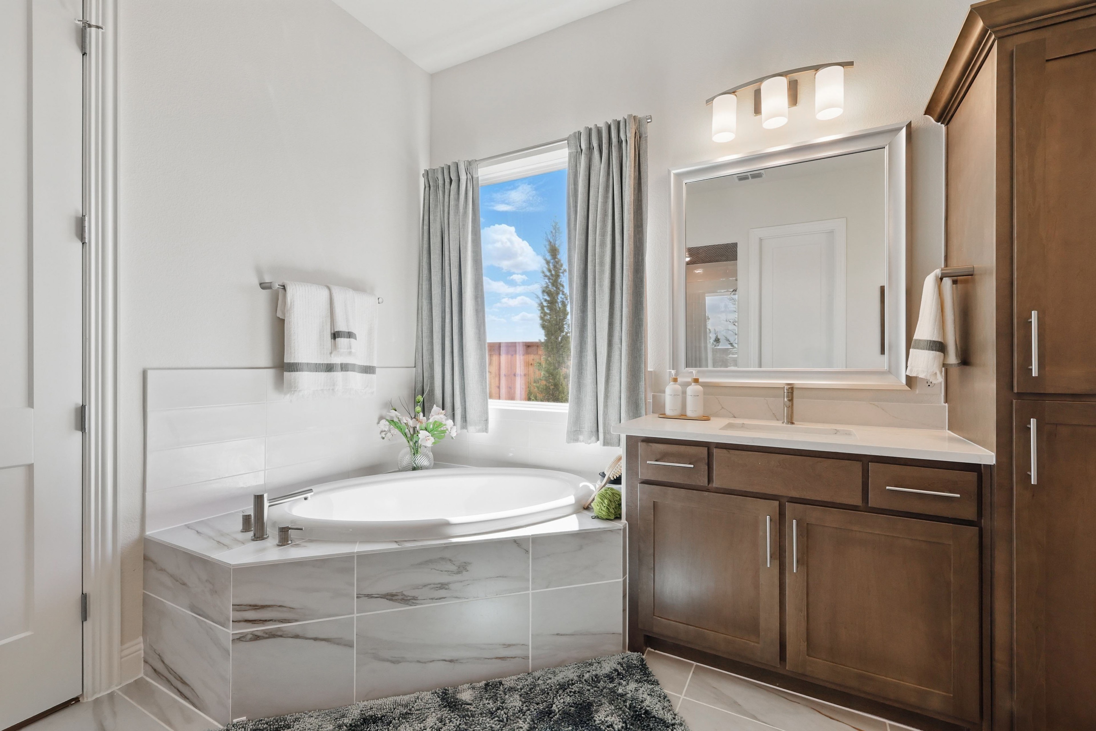 Elegant Bathroom with Marble and Wood at Rio Vista, Kelly Ranch Luxury bathroom with marble tiles, wood cabinets, large window, located in Rio Vista at Kelly Ranch.