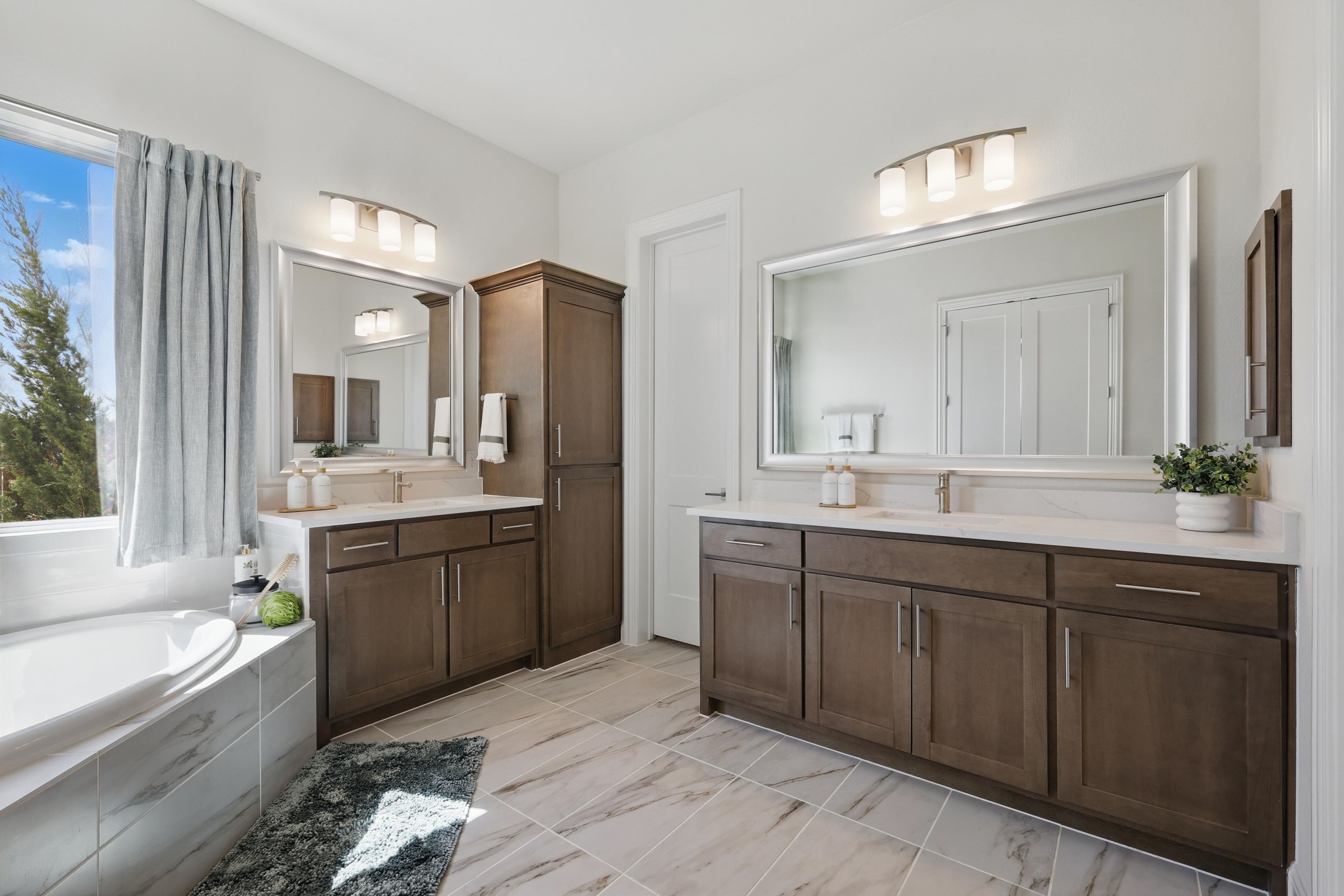 Rio Vista Kelly Ranch Luxury Bathroom with Dual Vanities Luxurious bathroom at Rio Vista, Kelly Ranch; dual sinks, wooden cabinetry, marble tile, natural light.