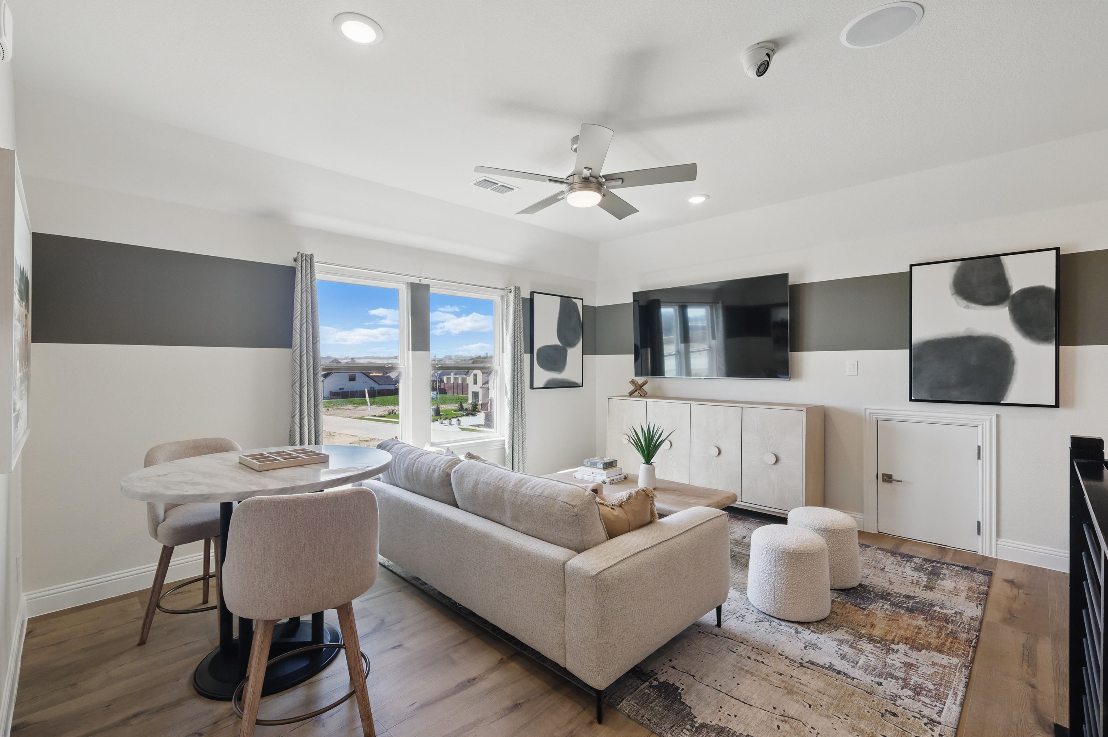 Modern Living Room at Rio Vista Kelly Ranch with Scenic View Modern living room with beige sofa, marble table, TV, abstract art in Rio Vista at Kelly Ranch, scenic view.