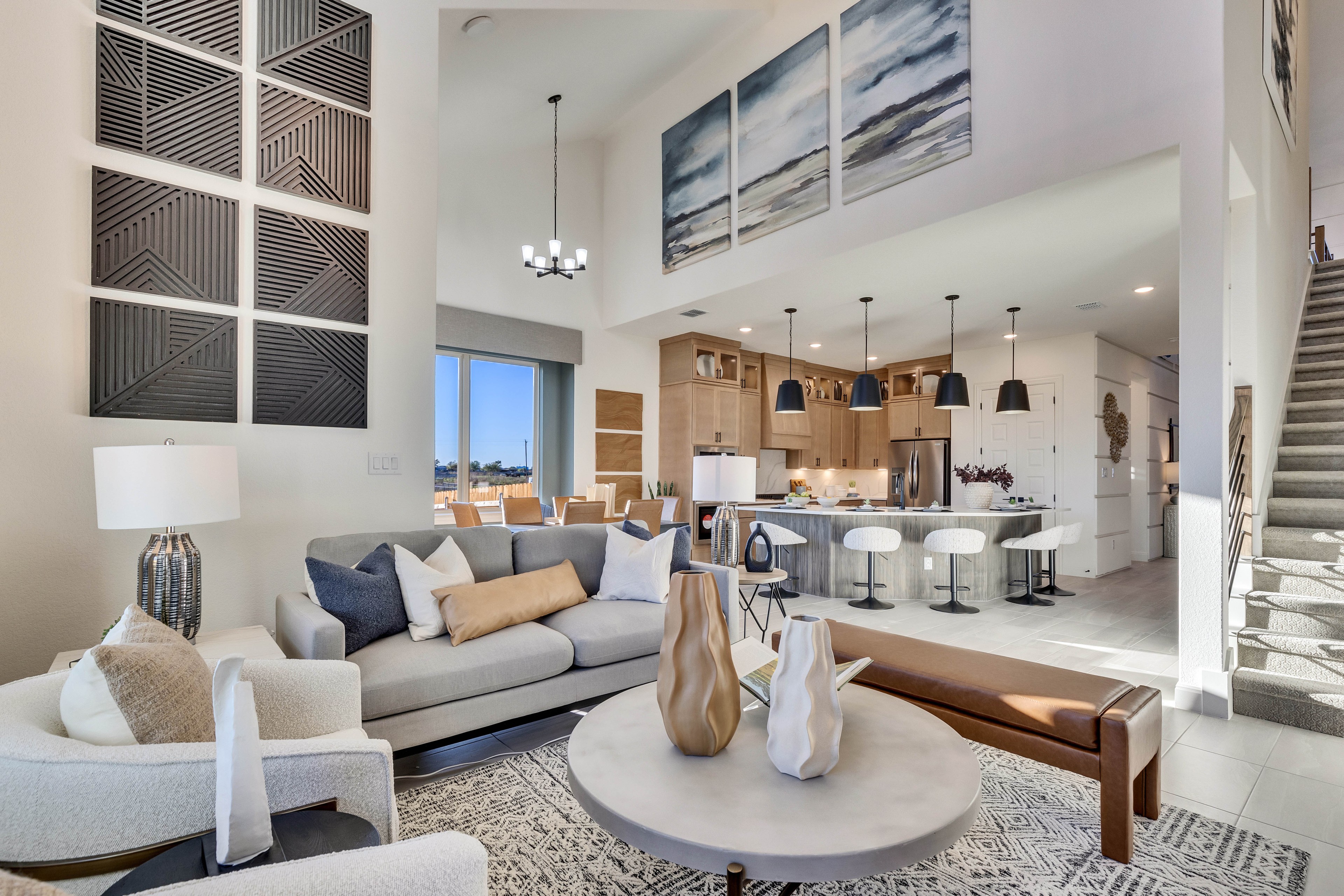 Contemporary Living Room and Kitchen in Creeks Crossing Modern living room with high ceilings, abstract art, open kitchen in Creeks Crossing community.