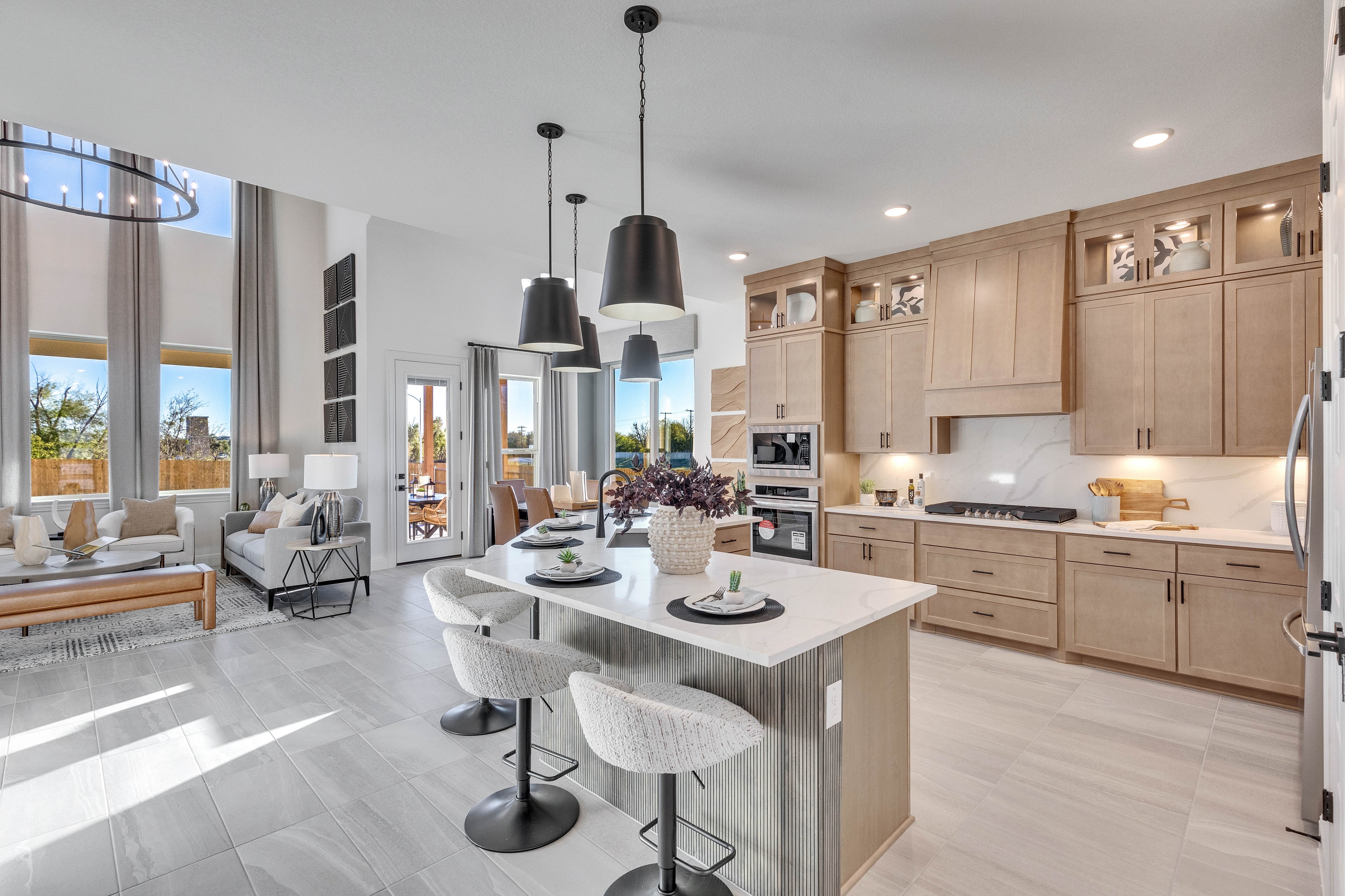 Modern Kitchen Design in Creeks Crossing Community Spacious modern kitchen with island, pendant lights, and floor-to-ceiling windows in Creeks Crossing community.