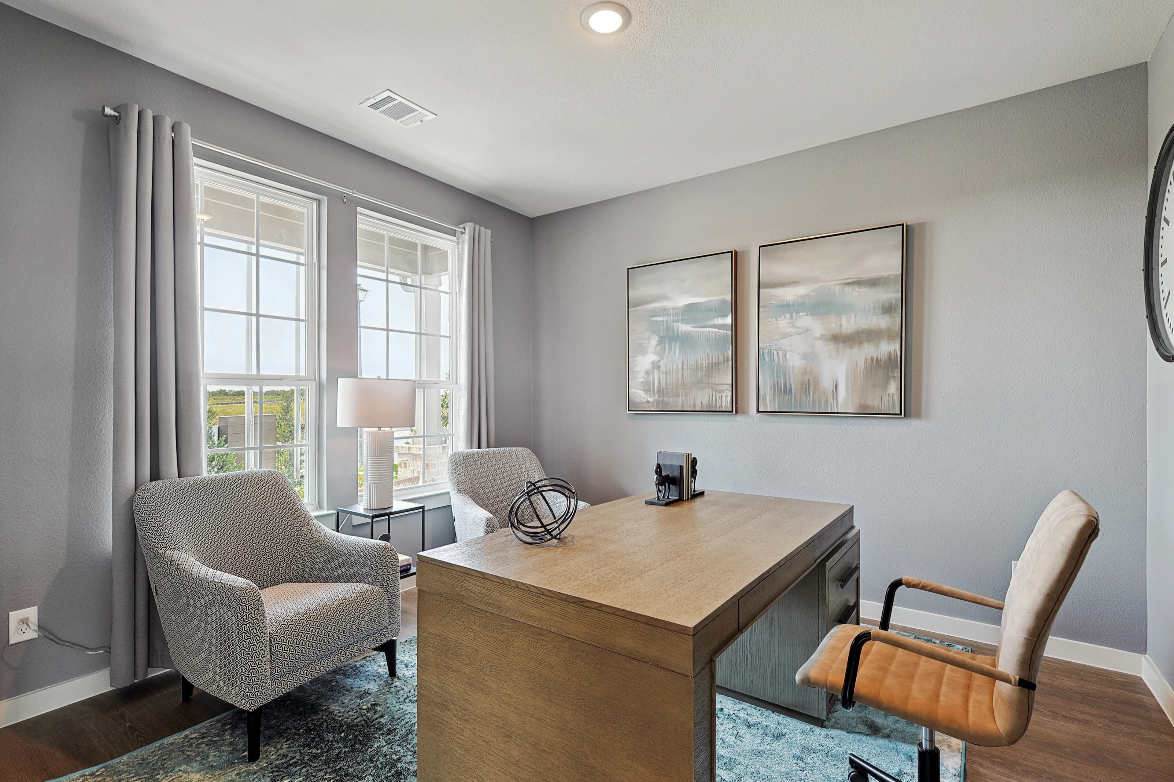 Elegant Modern Home Office in Patriot Estates with Large Windows Modern home office with light gray walls, large windows, patterned chairs, and elegant artworks in Patriot Estates.