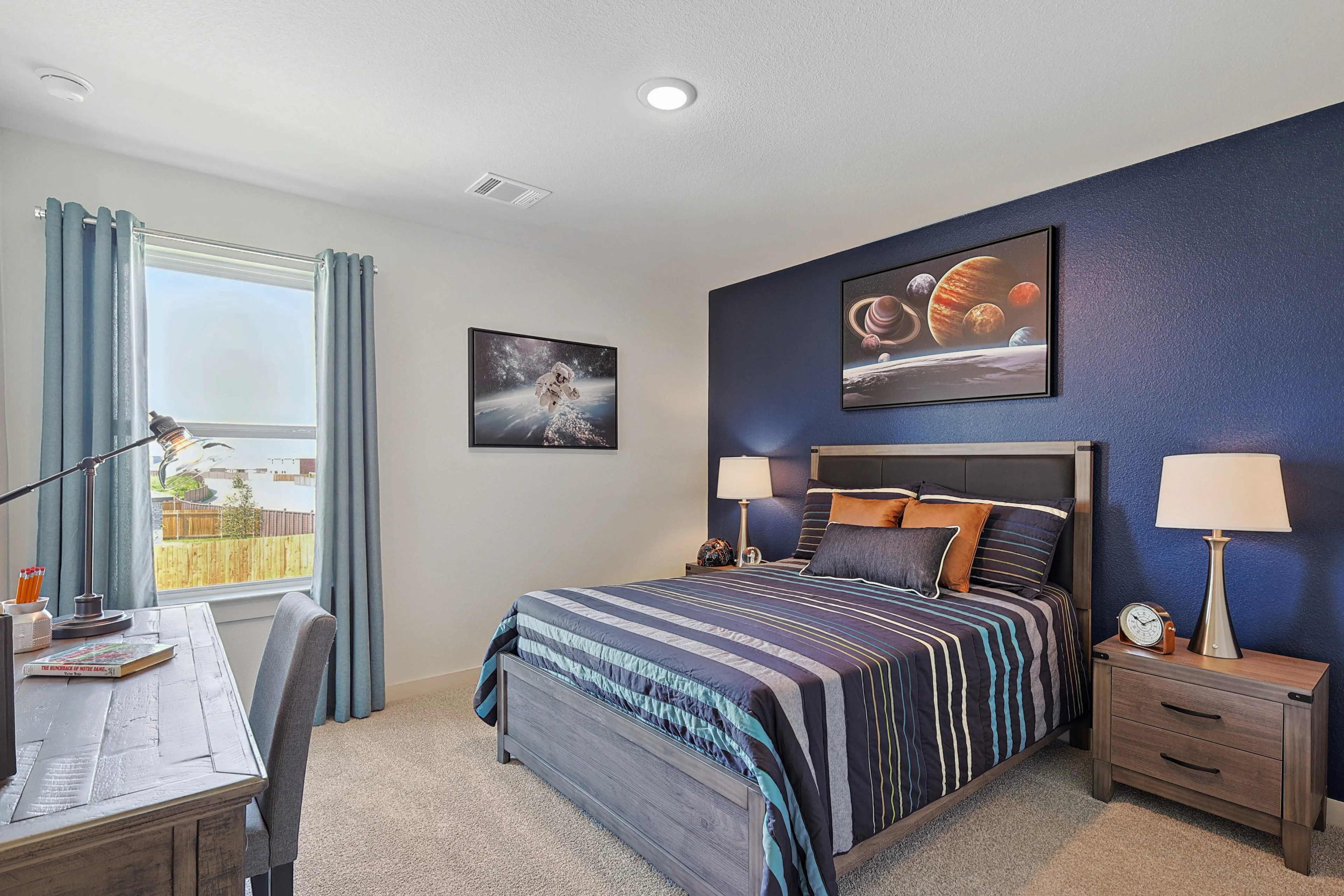 Patriot Estates Bedroom with Space Theme Decor Modern bedroom with blue accent wall, space-themed decor, wood furniture in Patriot Estates.